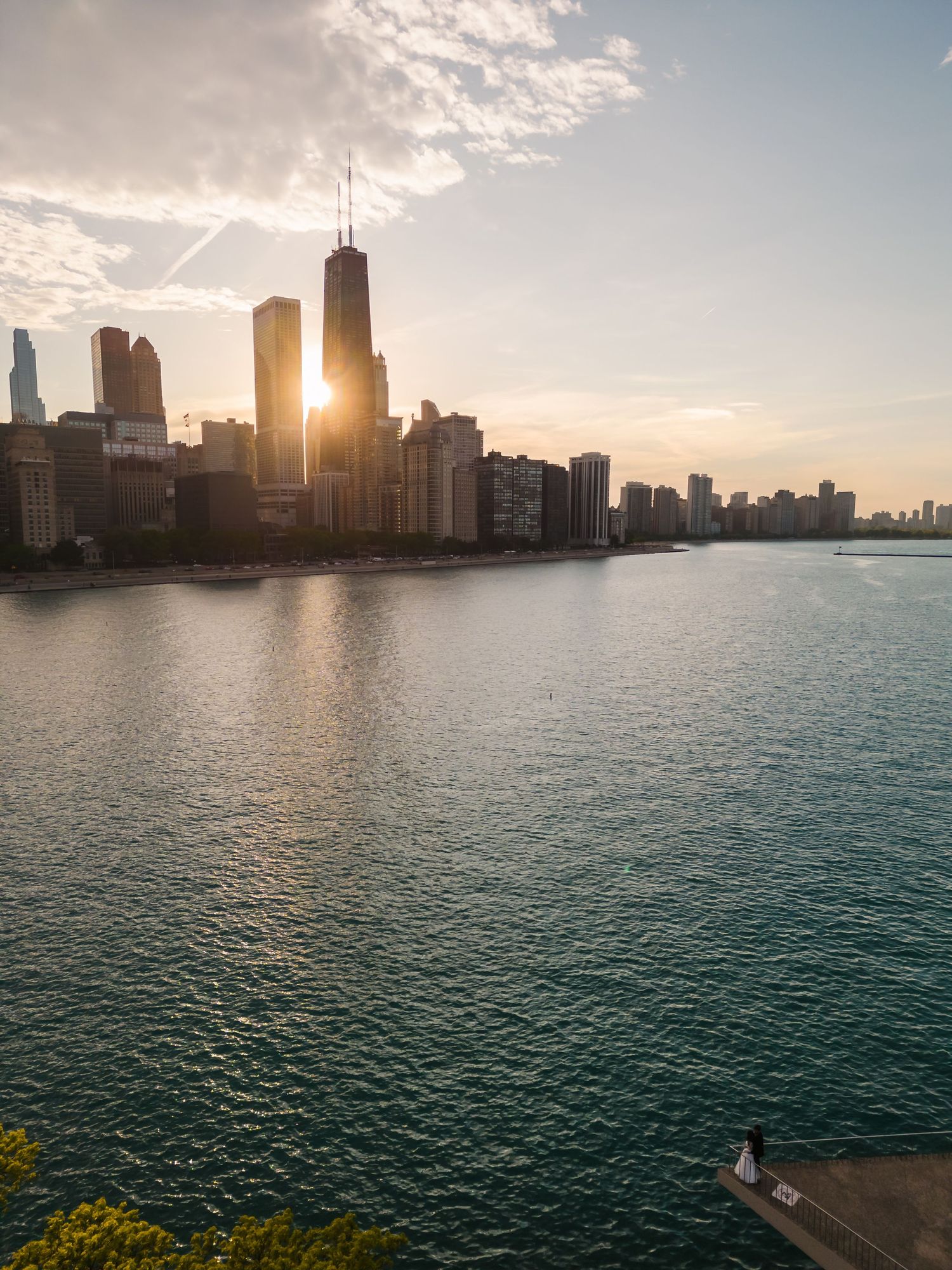 Chicago skyline at sunset with Lake Michigan in the foreground.