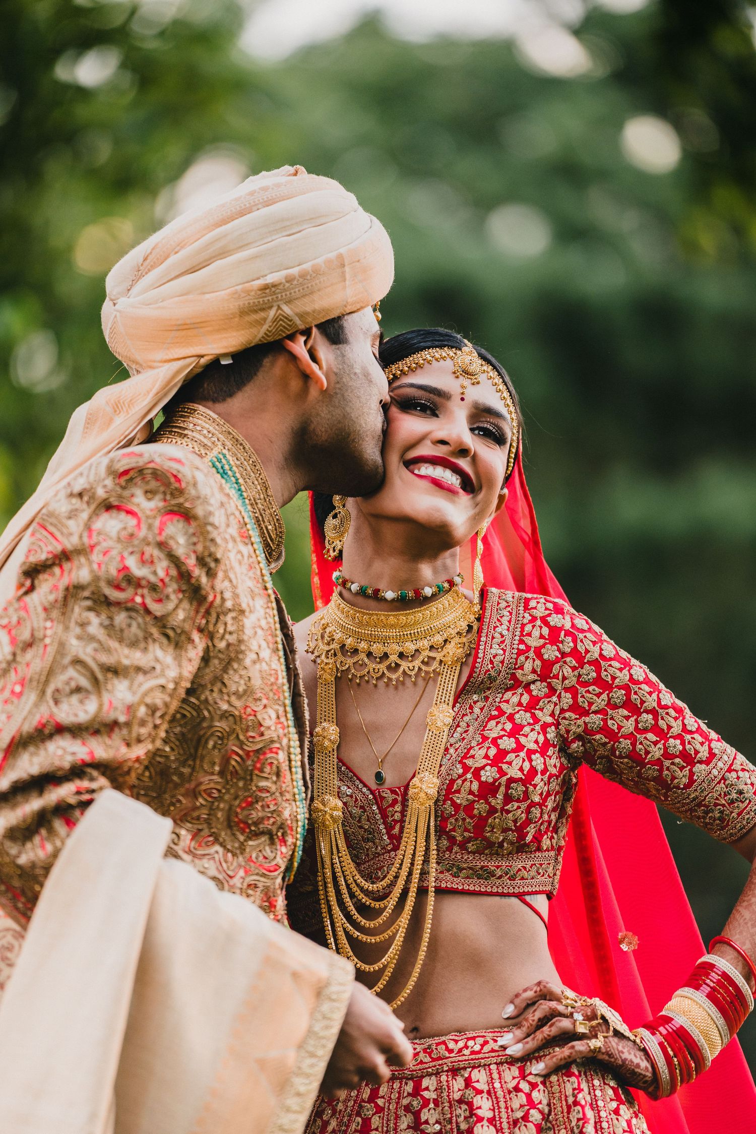 Joyful moment at an Indian wedding celebration with traditional attire and jewelry.