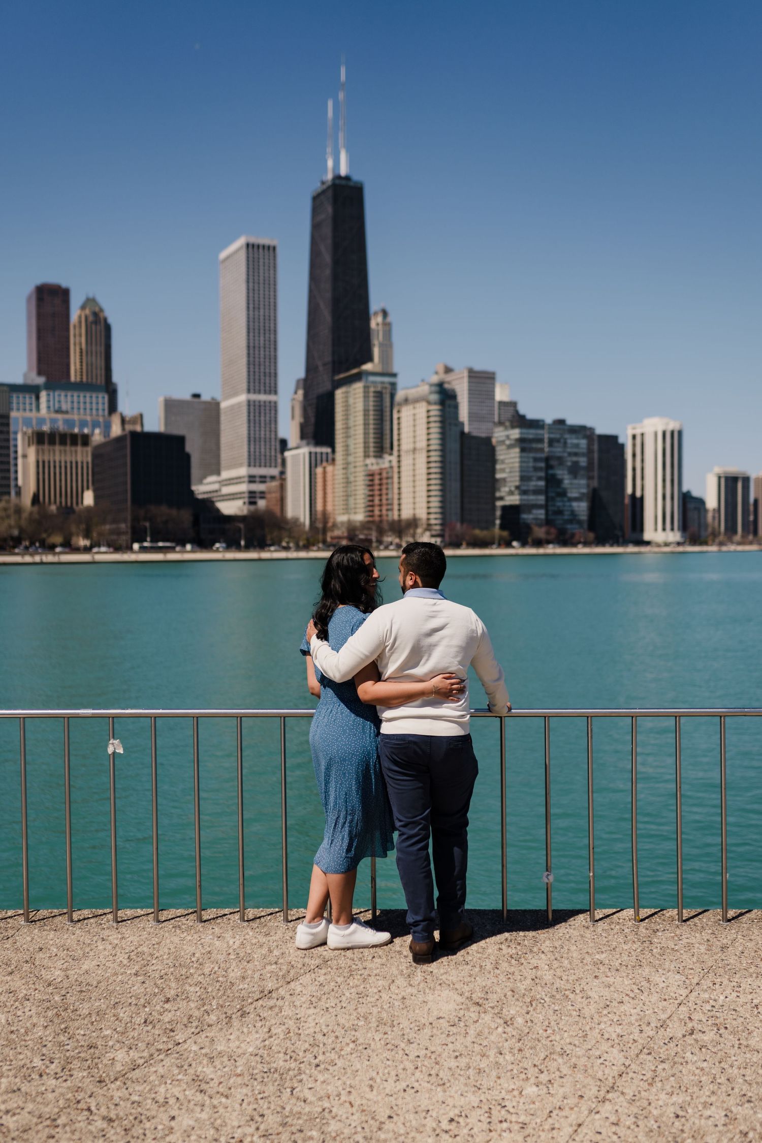 Couple embracing while viewing Chicago skyline from North Avenue Beach.