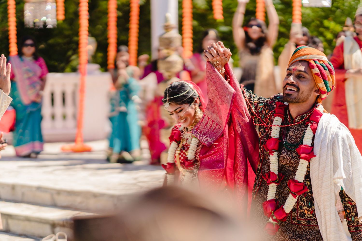 Energetic celebration during traditional Indian wedding ceremony with outdoor decor.