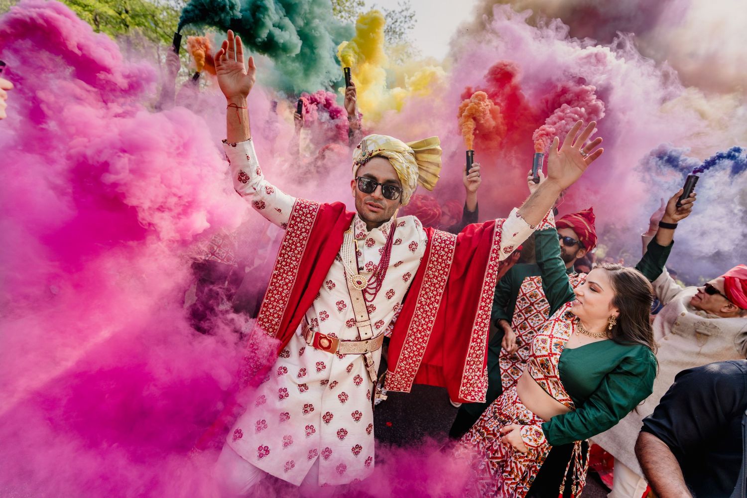 Joyous celebration with colorful powder explosions at an Indian wedding ceremony.