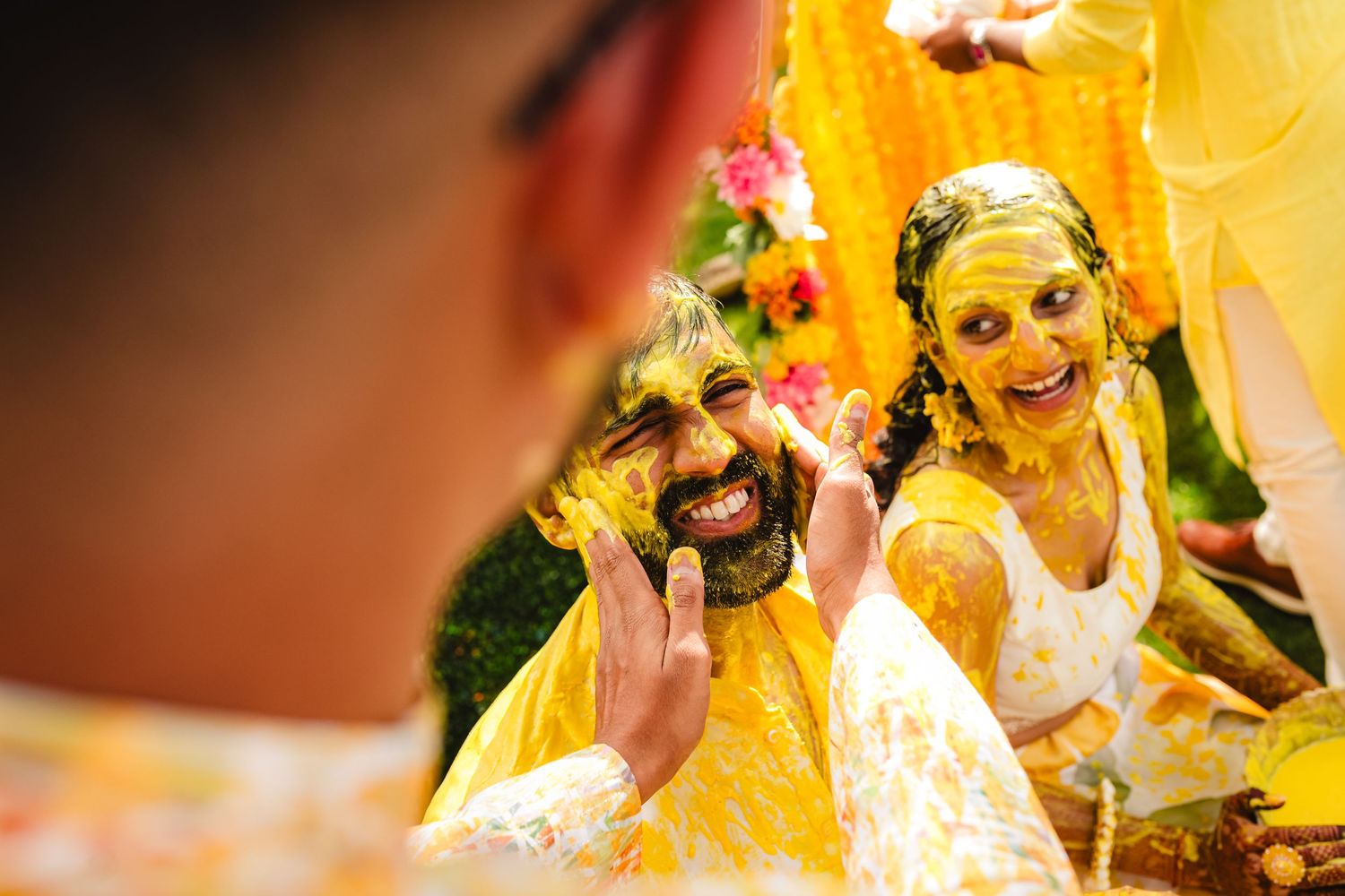 Joyful celebration at Indian Haldi ceremony with bright yellow turmeric paste and colorful decorations.