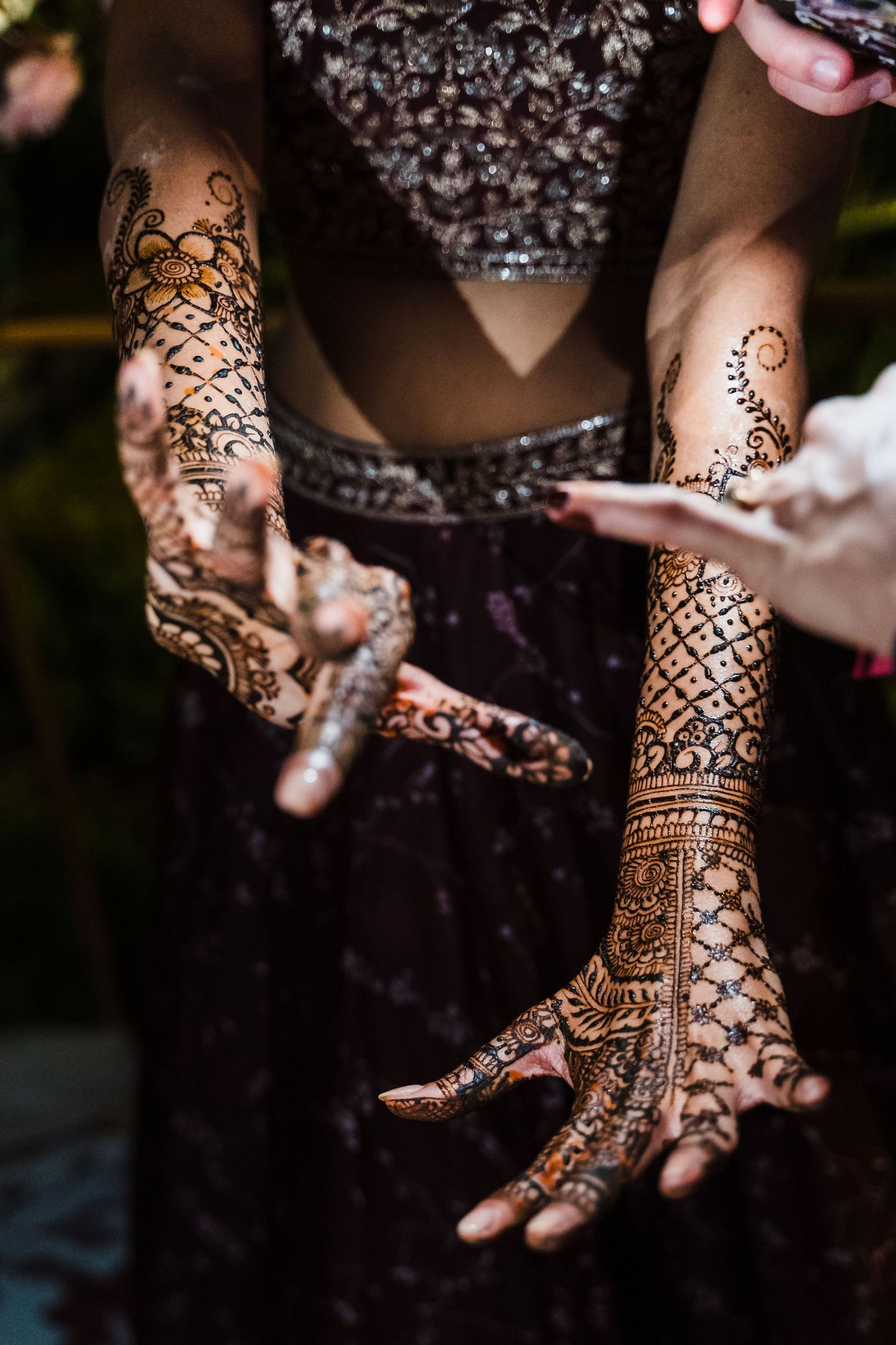 Intricate henna mehndi designs adorning hands and arms with detailed floral and geometric patterns.