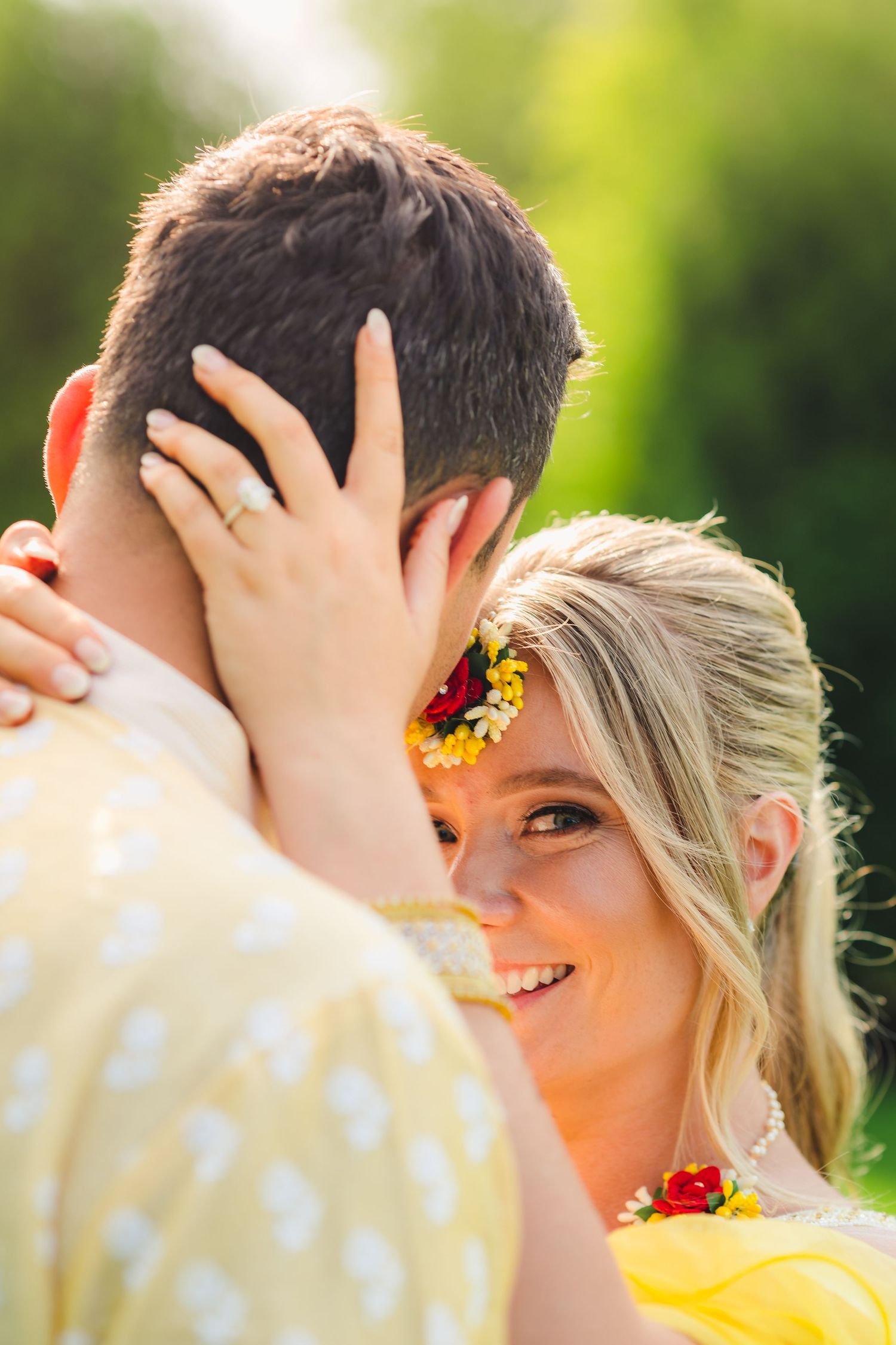 Intimate wedding photography moment with couple embracing in golden sunlight.