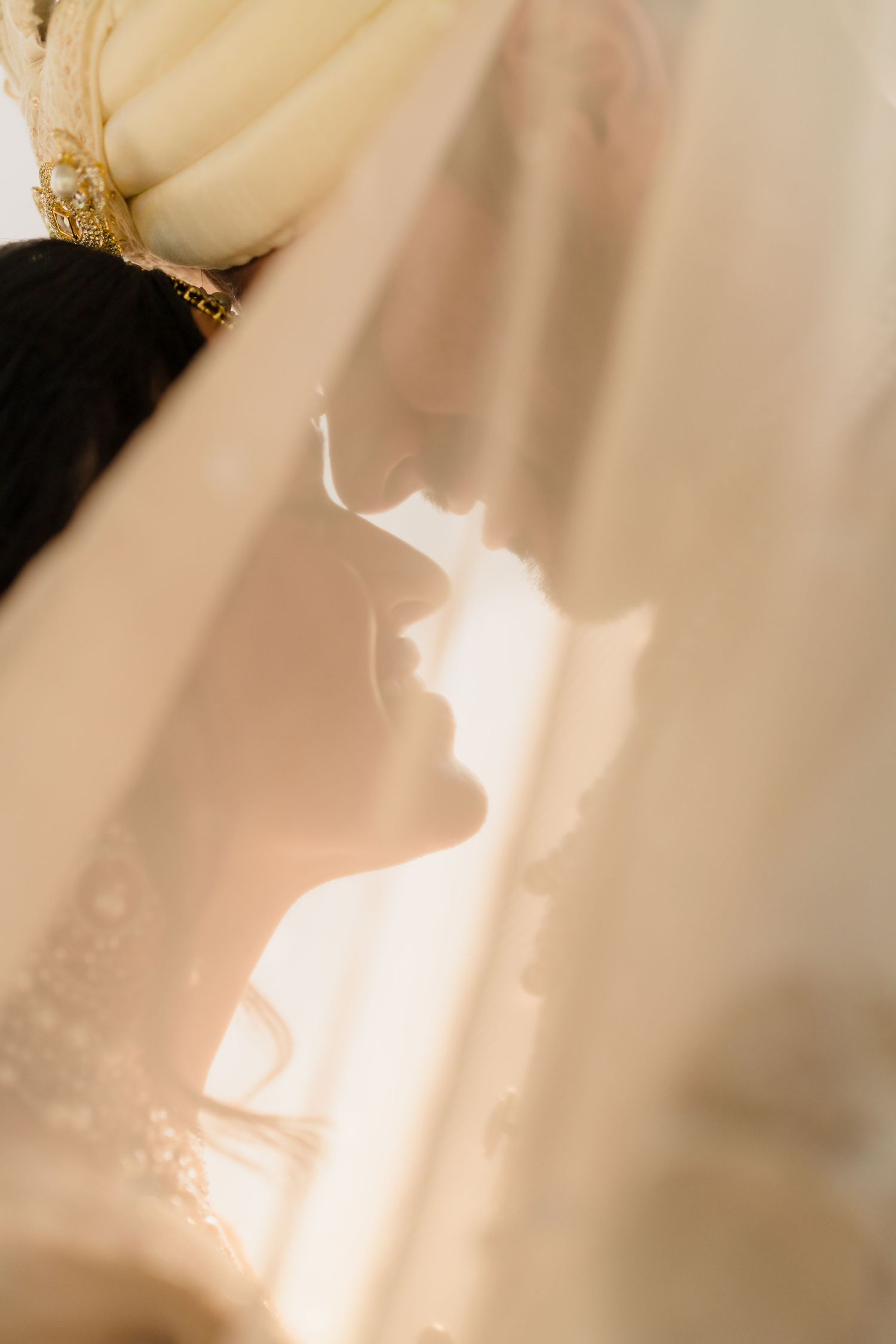 Silhouette profile shot through sheer fabric creating dreamy wedding portrait.