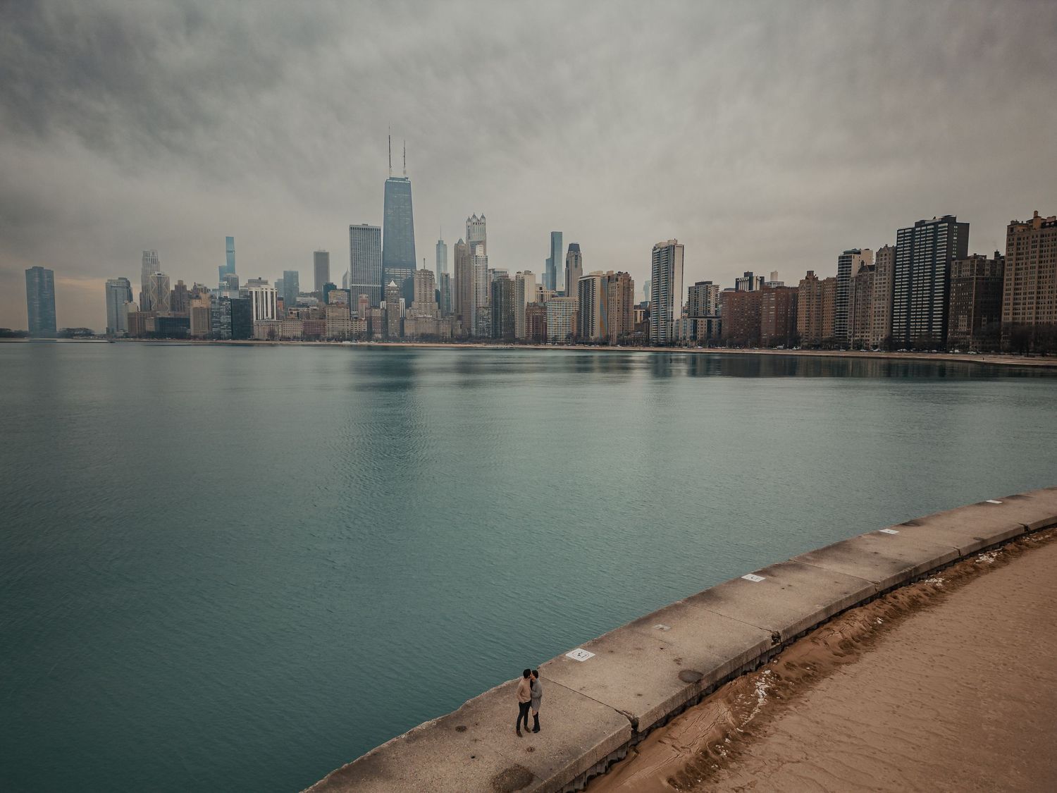 Dramatic cityscape of Chicago's skyline reflected in Lake Michigan on a moody day.