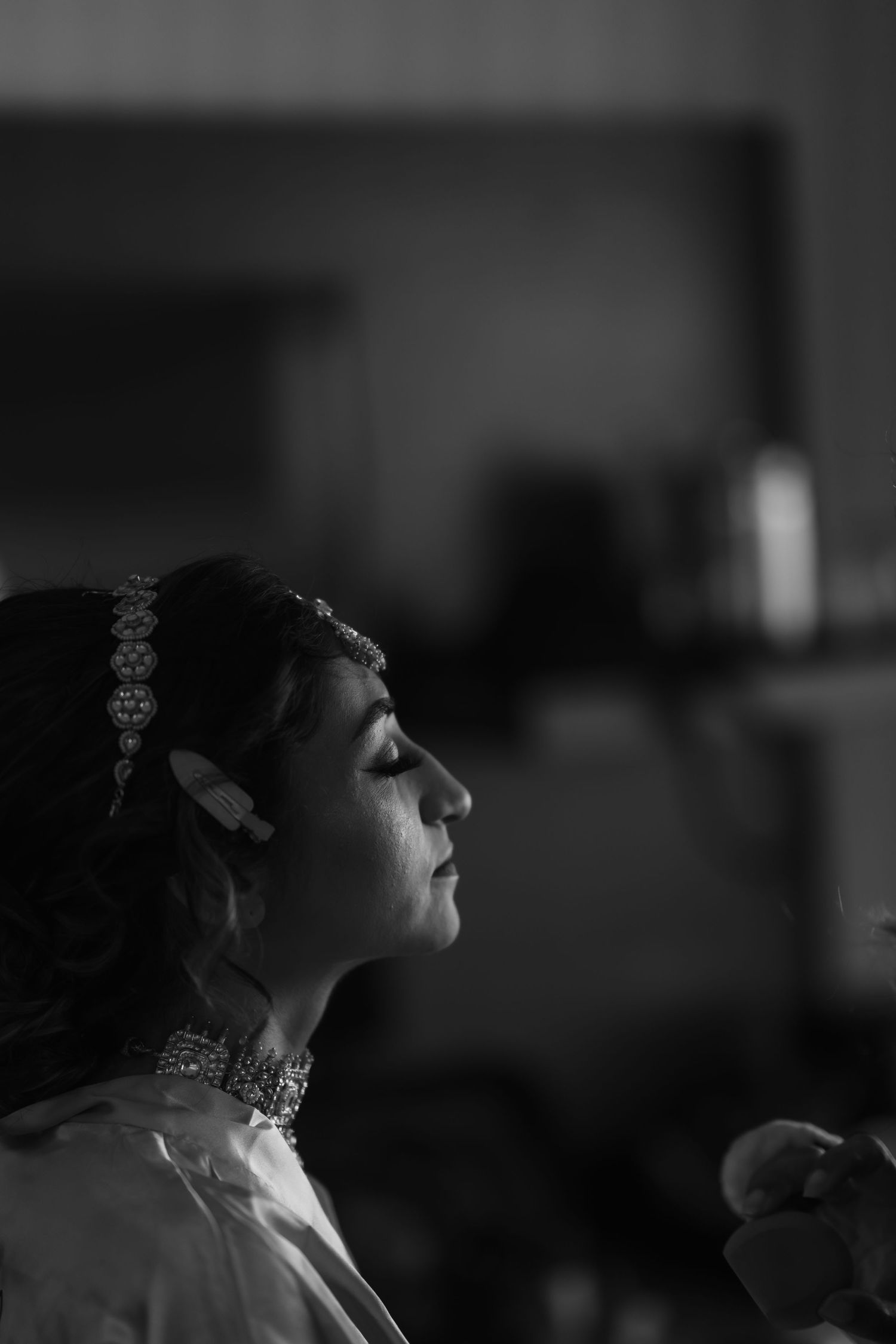 Dramatic black and white profile portrait showing traditional Indian bridal jewelry.