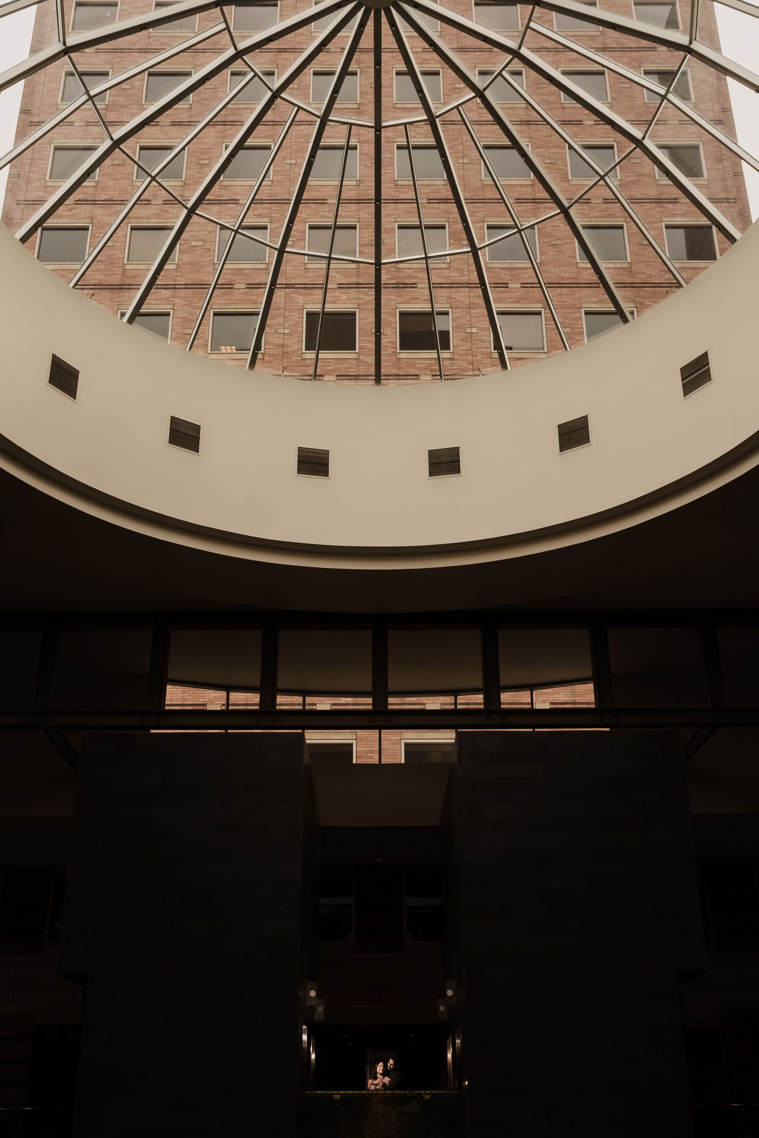 Interior architectural photo showing a dramatic domed glass ceiling with geometric patterns in a modern building atrium.