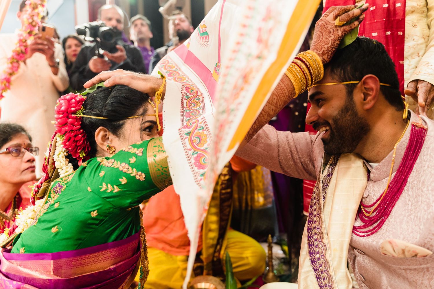 Colorful Indian wedding ceremony shows guests celebrating with traditional attire and customs.