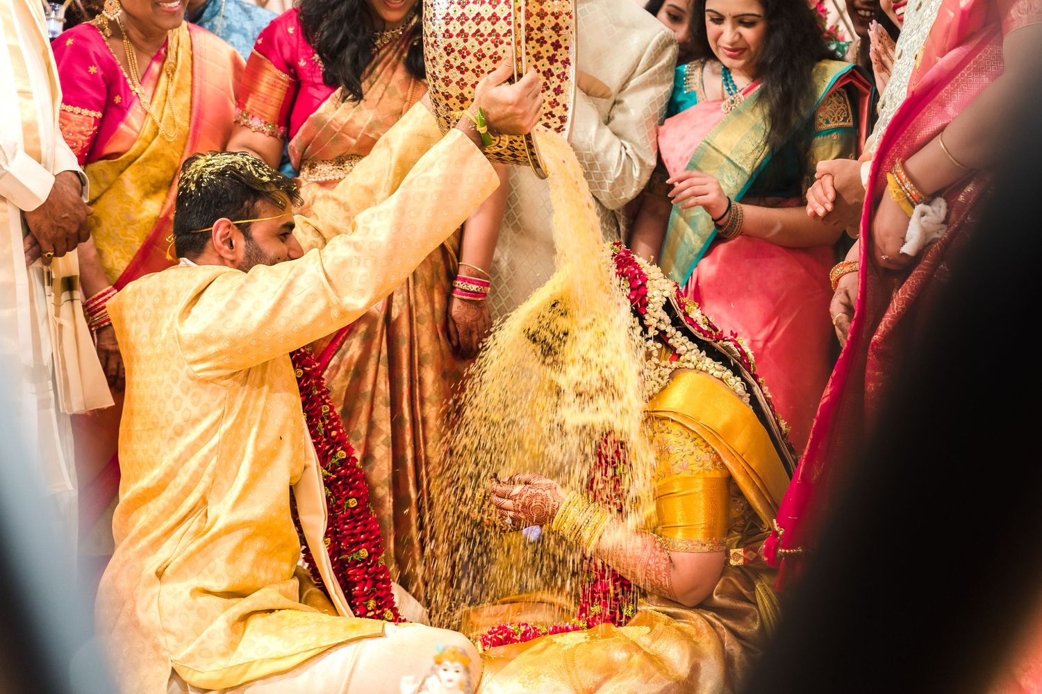 Celebratory moment during Indian wedding ceremony with turmeric powder being thrown.