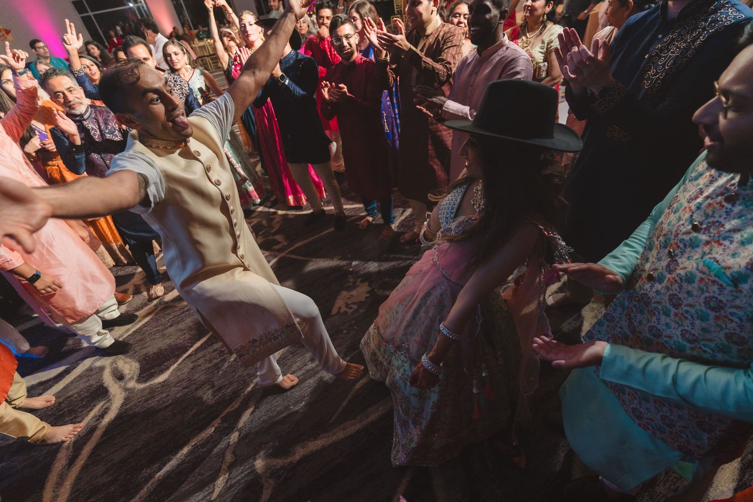 Lively wedding reception dance floor with guests in colorful traditional attire.