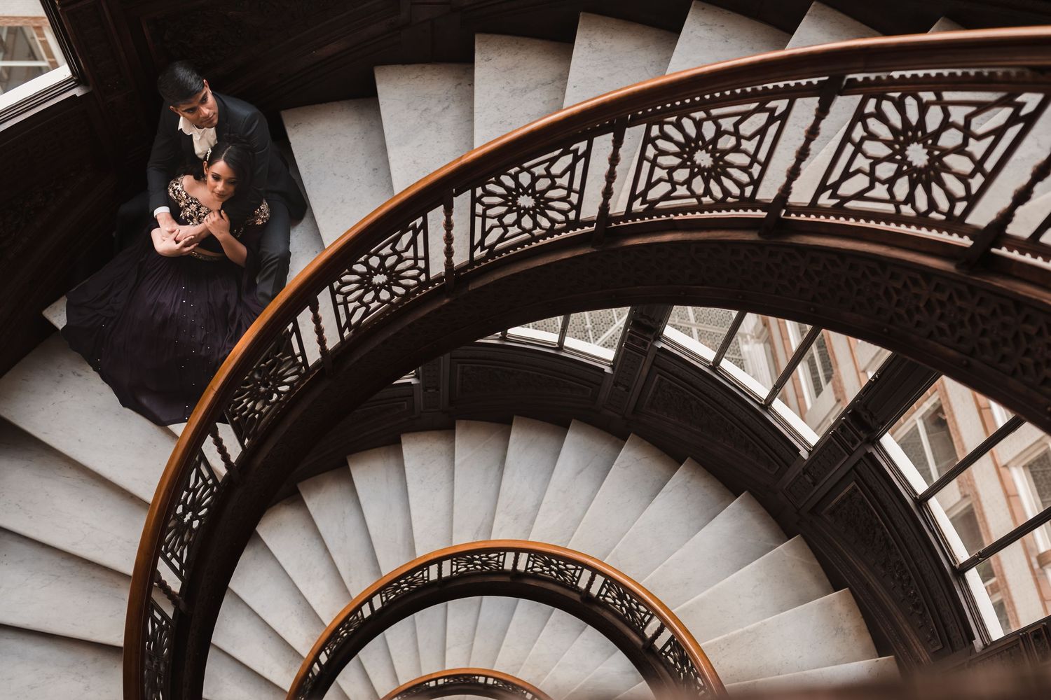 A spiral staircase with intricate iron railings photographed from above.