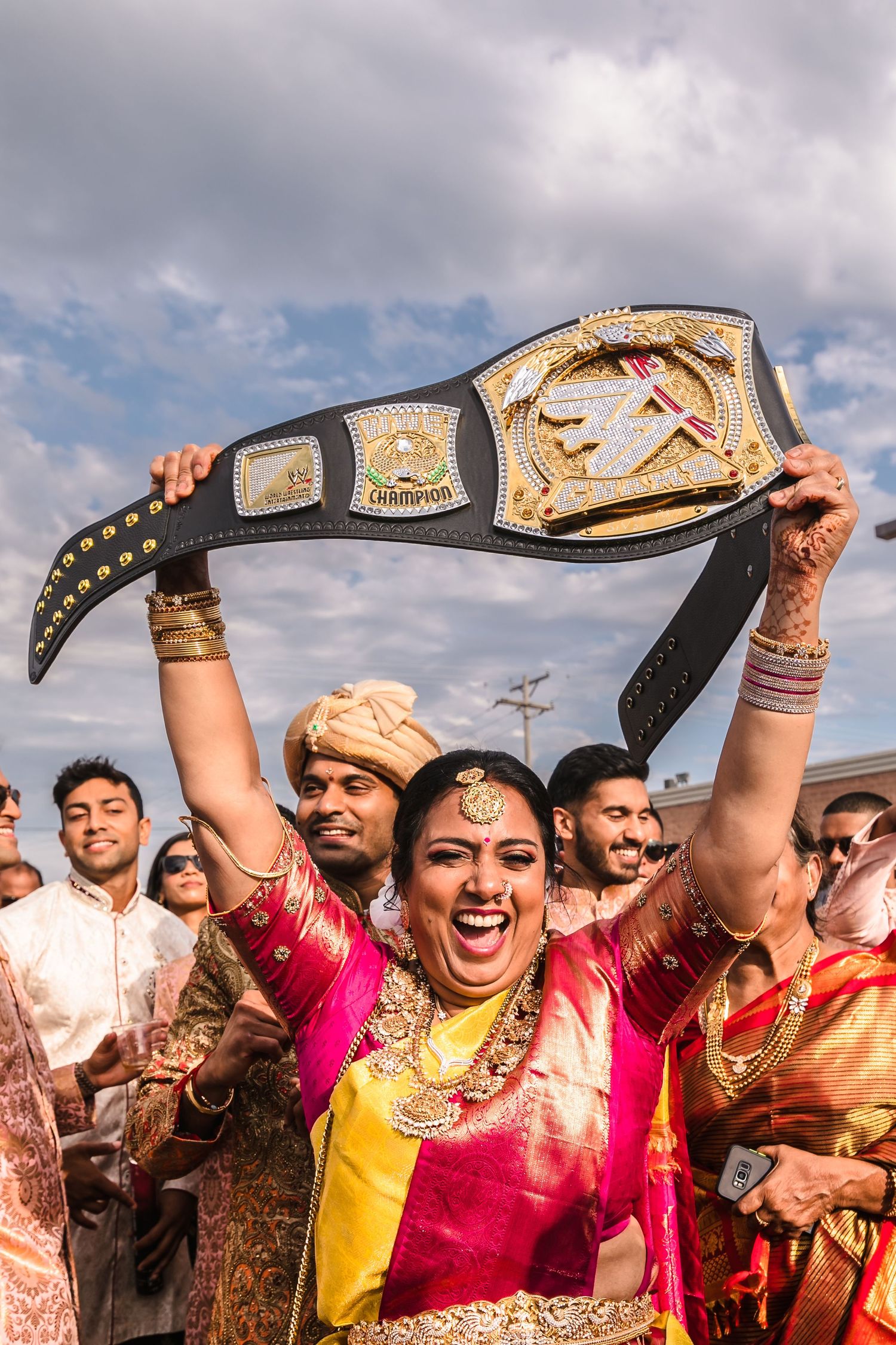 Celebrating with a WWE championship belt at an Indian wedding celebration.