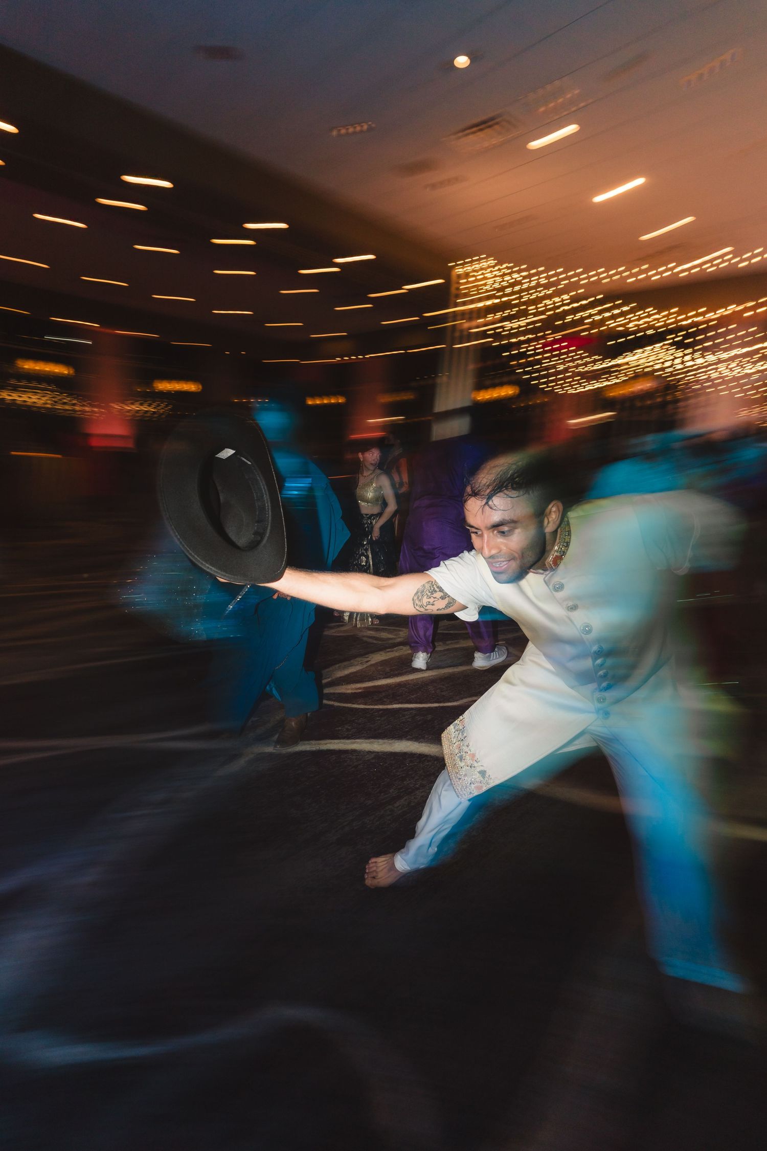 Motion-blurred photo of energetic dance moves at a wedding reception.