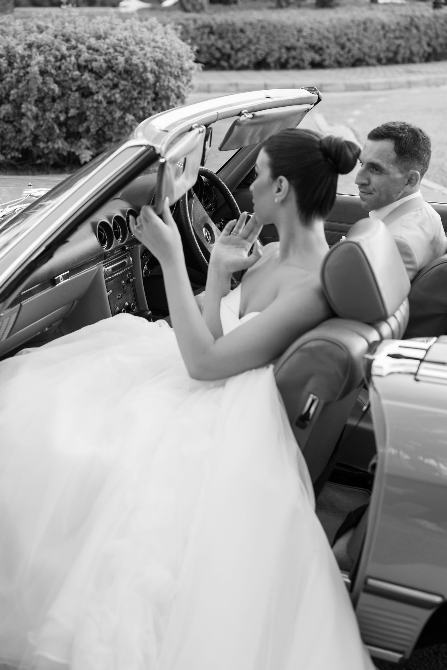 Black and white sequence showing a bride in a flowing gown getting into a car.