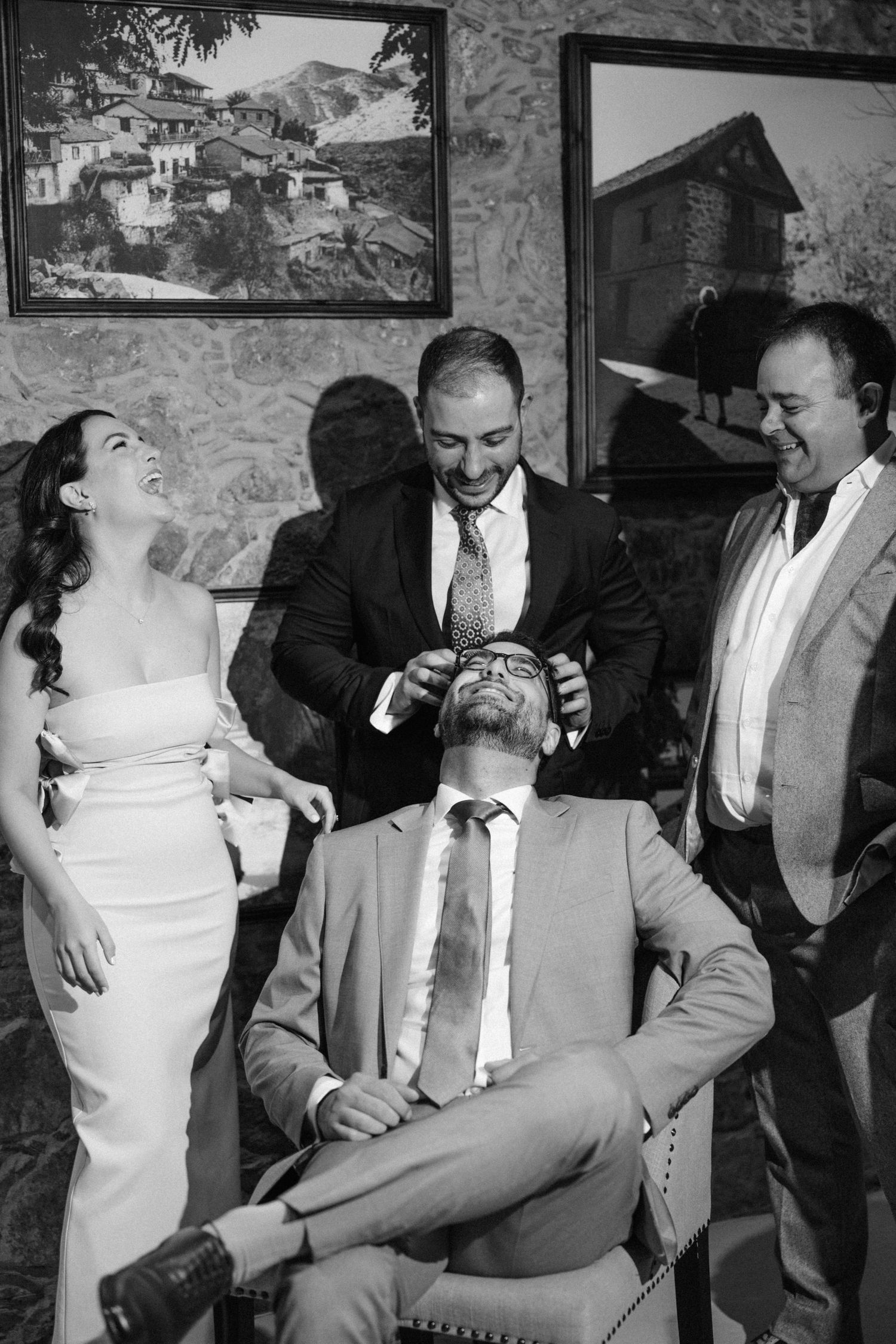 A festive black and white photograph showing a joyful moment with a group during a wedding celebration or social gathering.