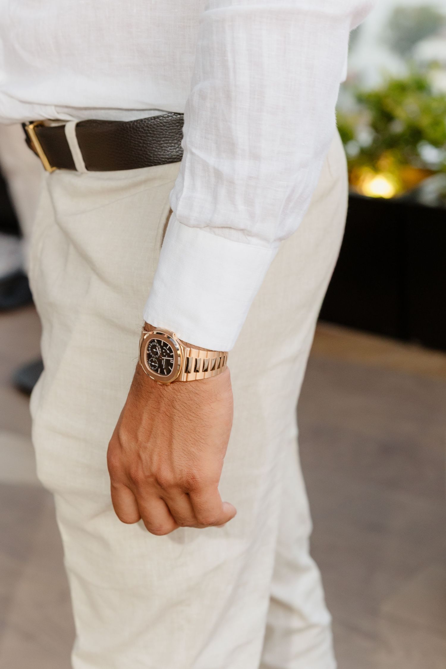 Close-up detail of a formal white sleeve with a wristwatch.
