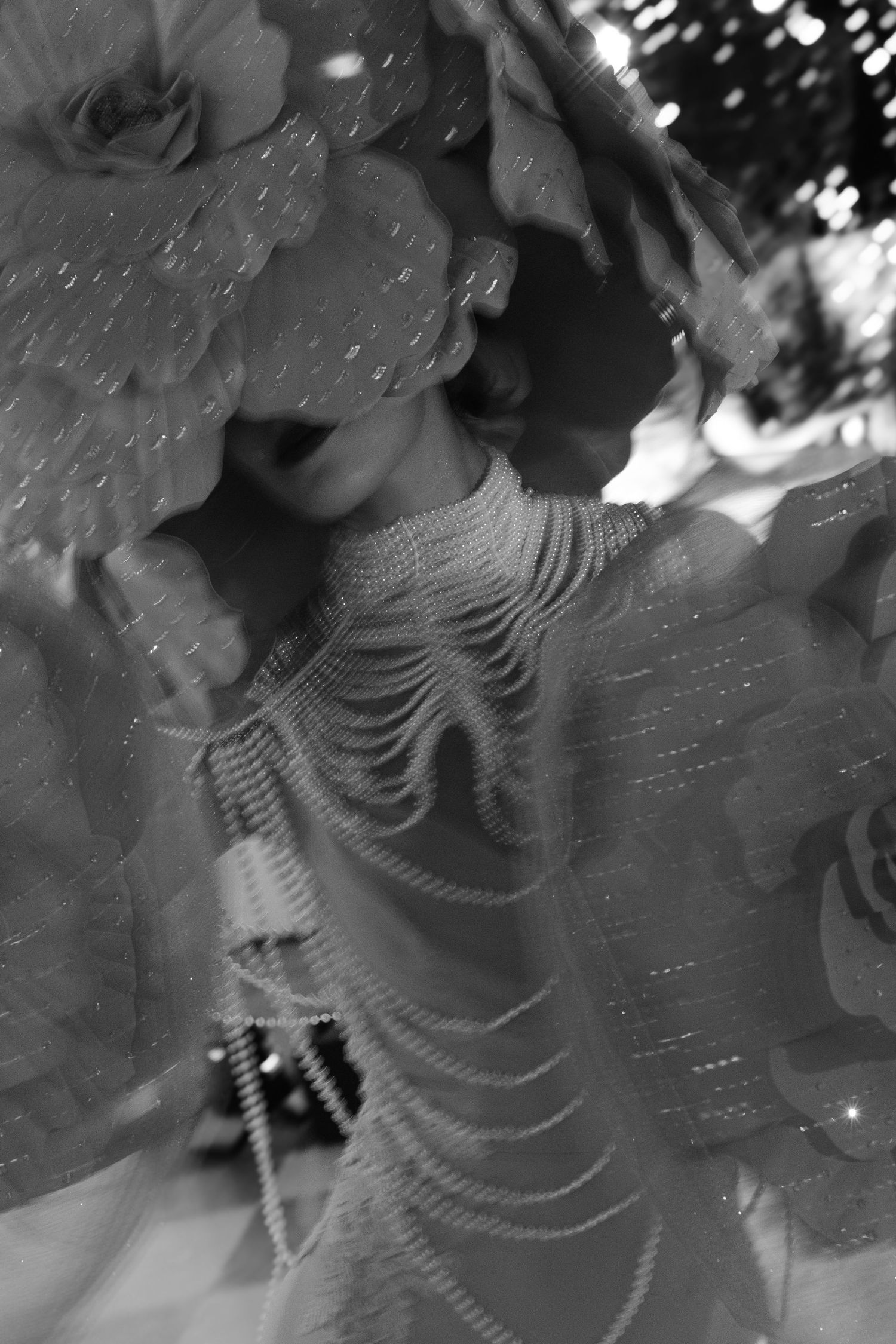 Artistic black and white portrait with beaded details and dramatic lighting effects.