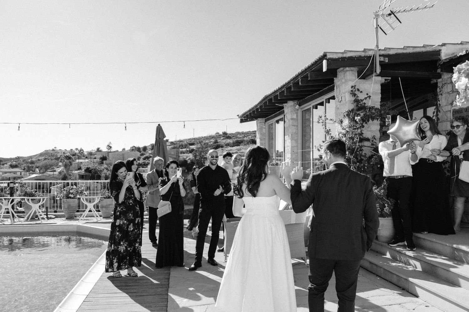 Wedding celebration on a rooftop terrace overlooking a hillside town.