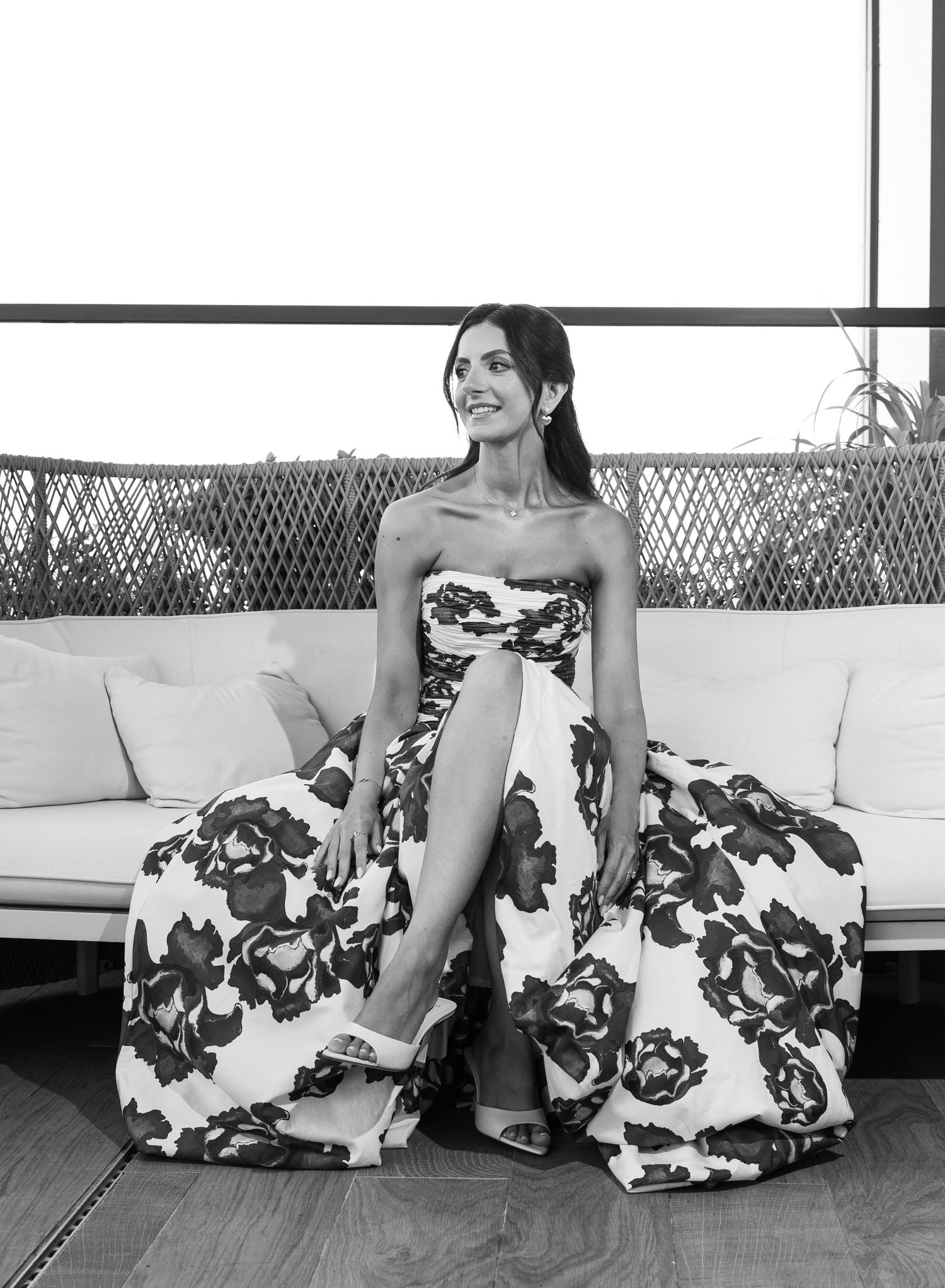A floral black and white dress is elegantly draped across a sitting area in an artistic photo sequence.