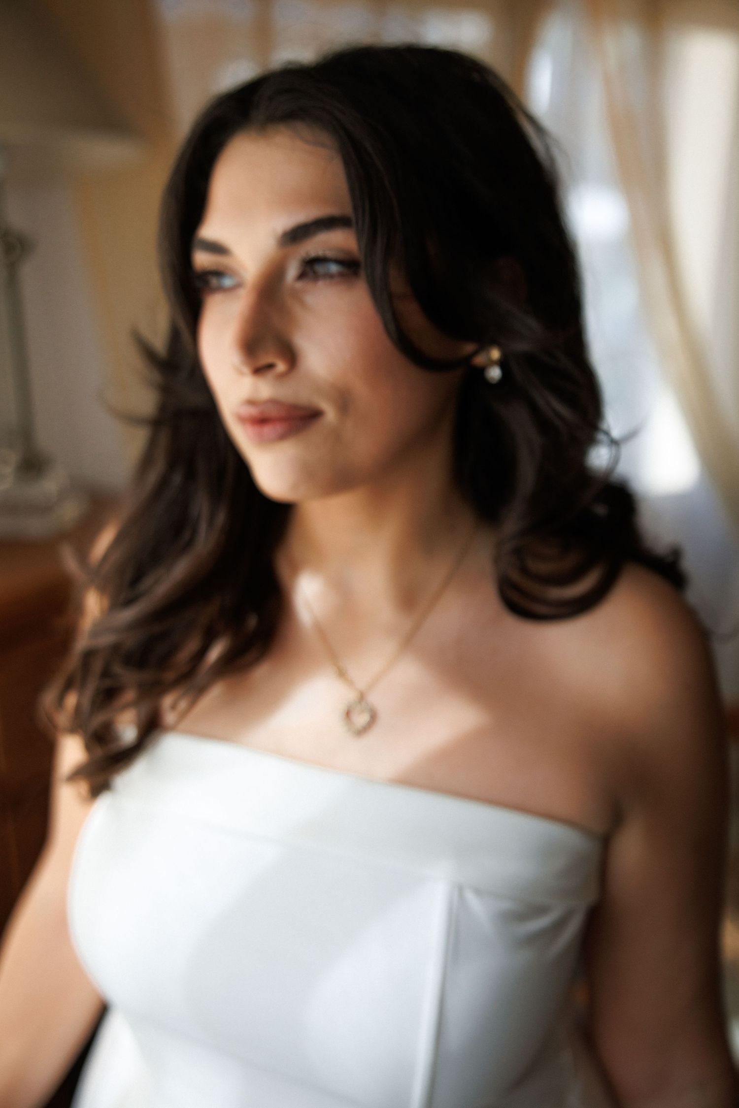 An elegant bridal portrait featuring soft lighting and delicate jewelry.