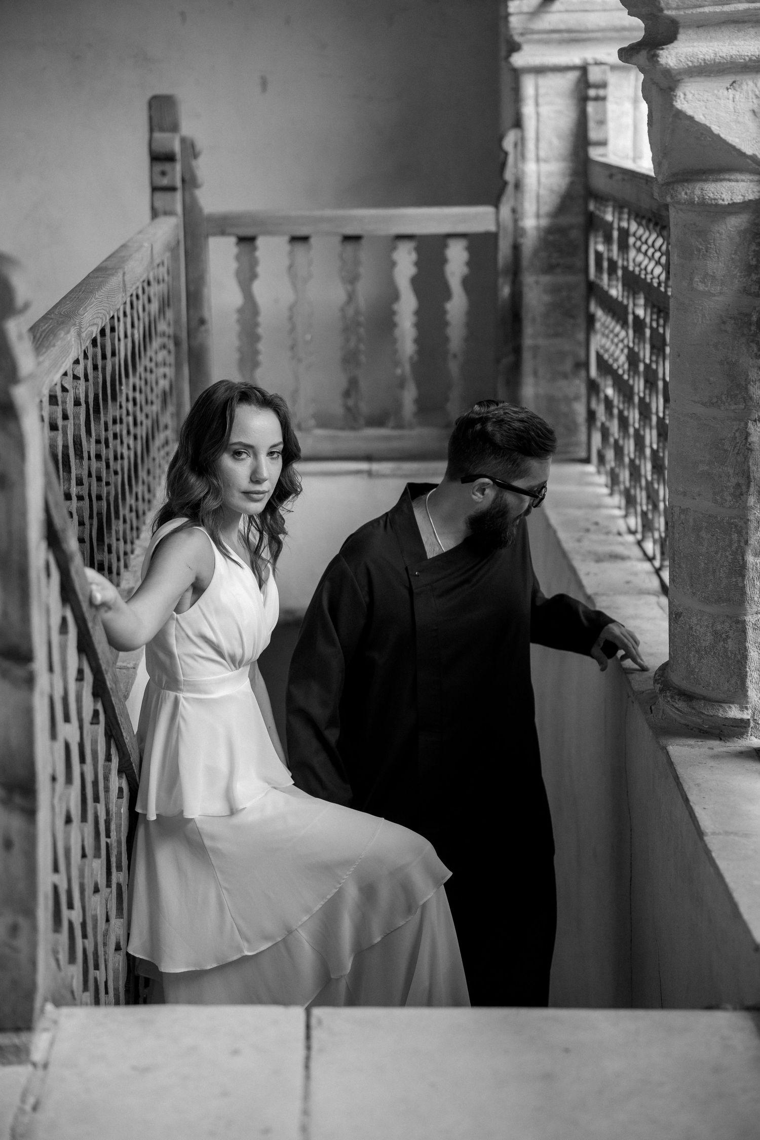 Dramatic black and white photo sequence of a couple posing along a vintage balustrade.