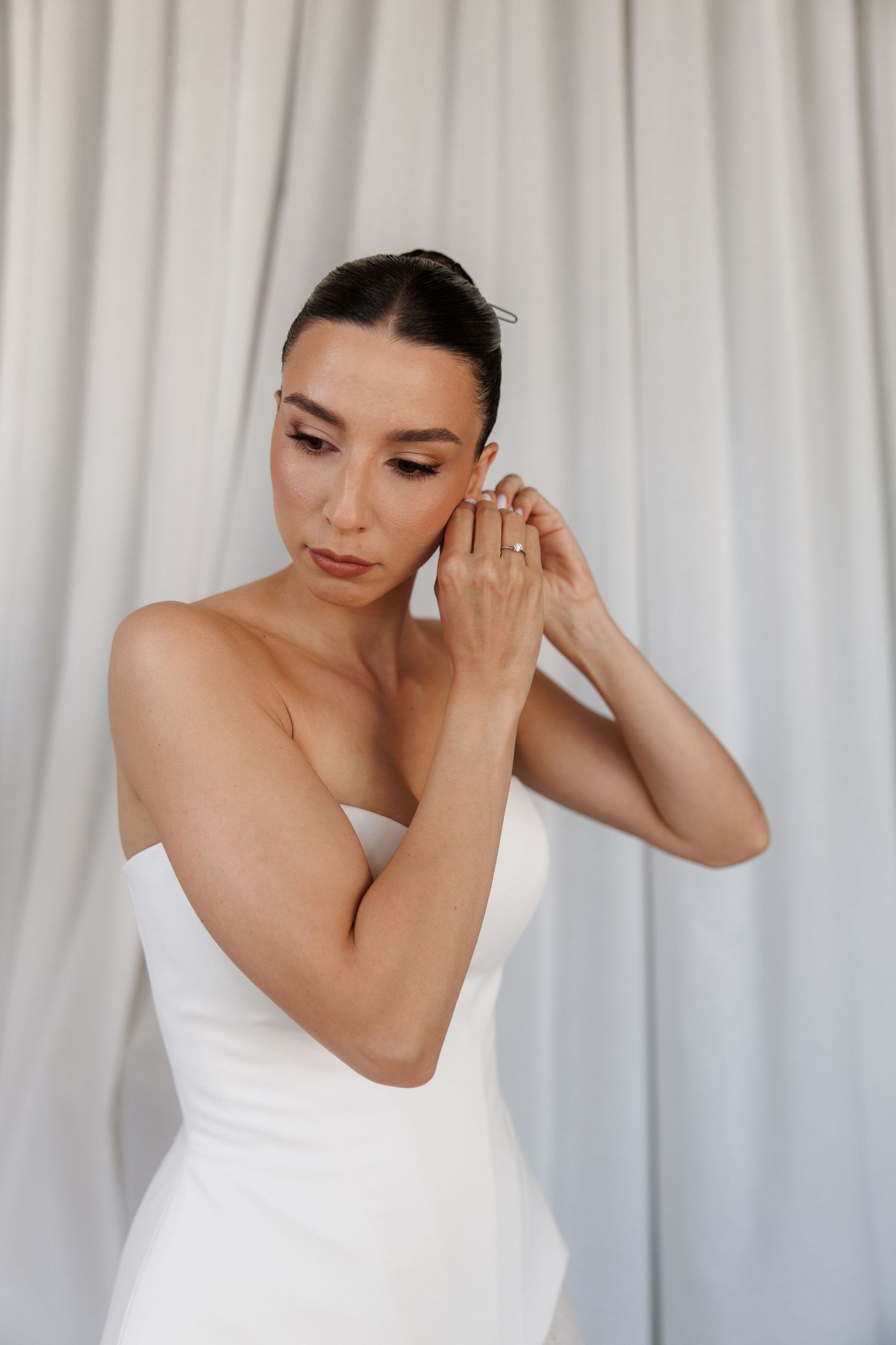 White wedding dress details against a draped fabric backdrop.