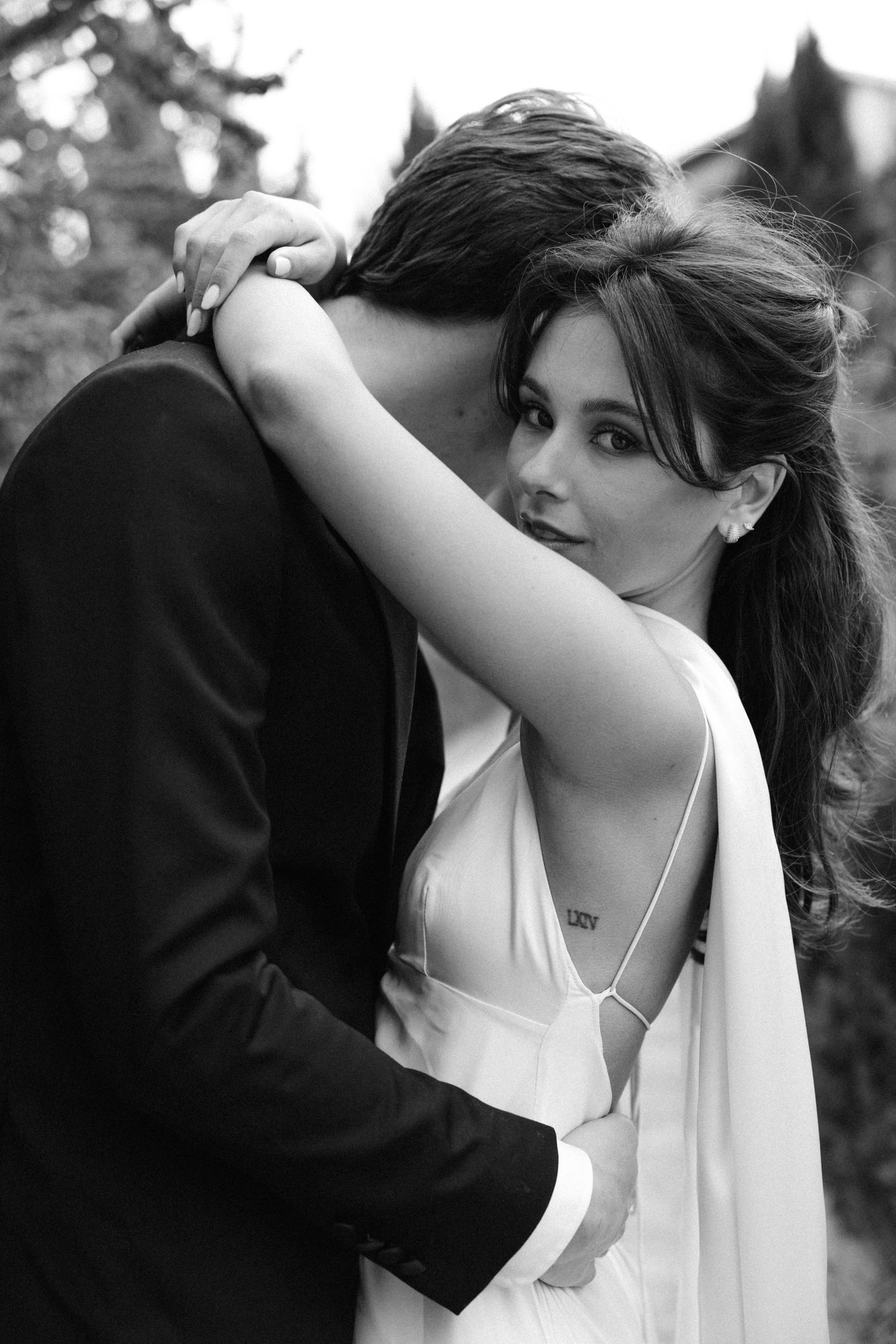 Romantic black and white portrait of a couple embracing in an intimate moment during their wedding photoshoot.