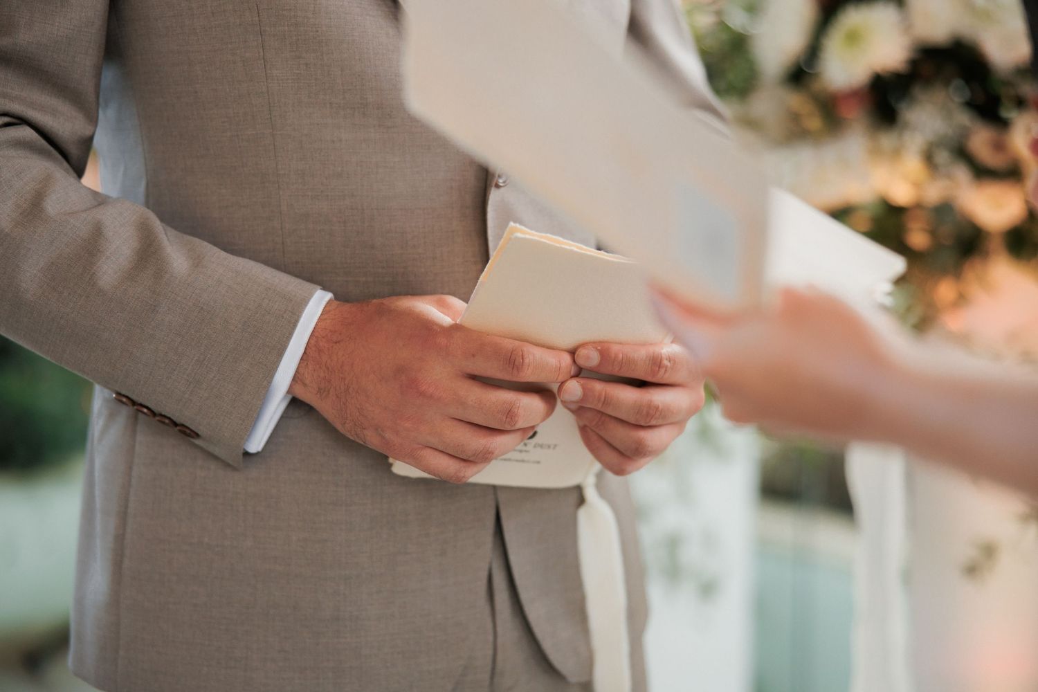 Close-up of hands exchanging rings during wedding ceremony.