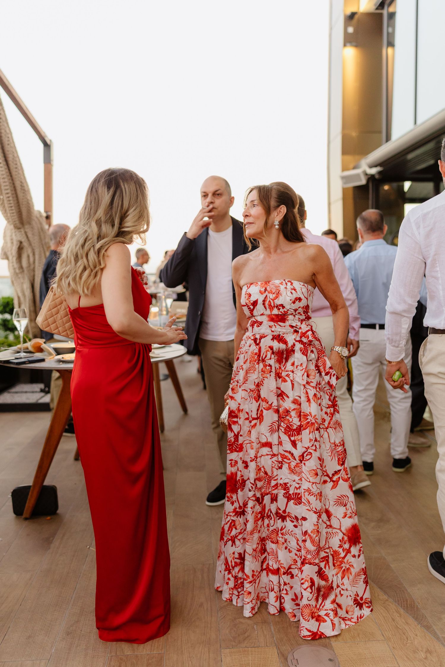 Guests in formal attire socializing at an elegant outdoor event.