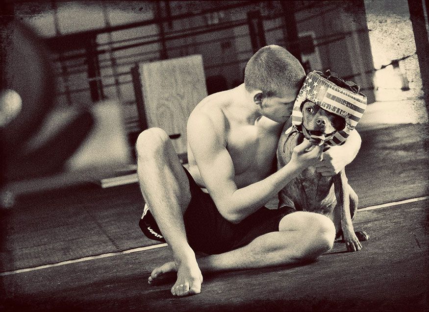 Black and white photo of a person embracing a dog during an emotional moment.