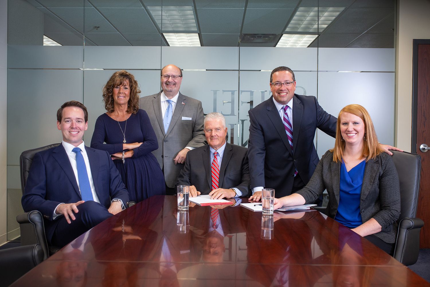 Business team meeting around conference table in office setting.
