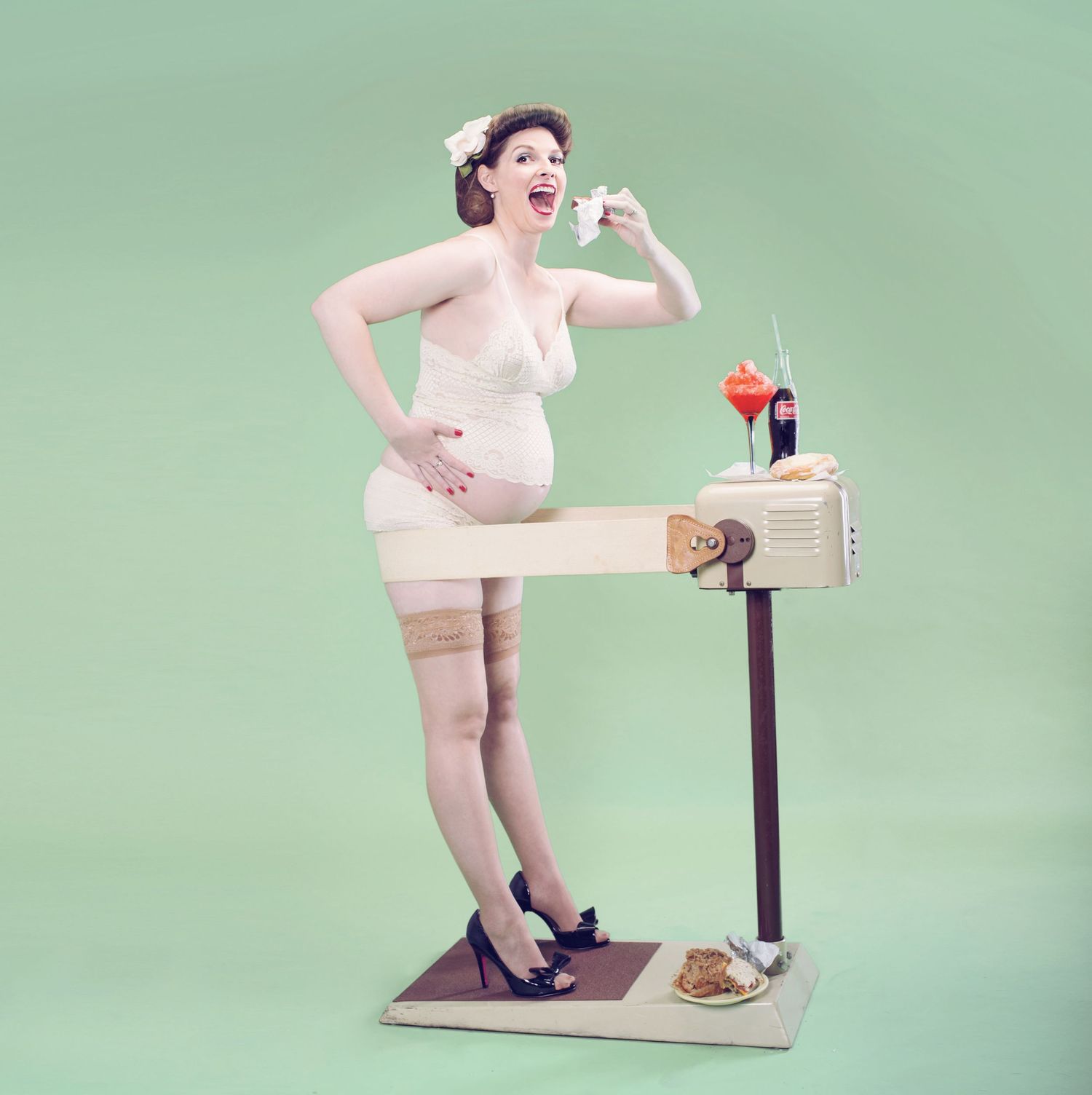 Vintage-style photo of a pin-up model posing on a retro weight scale with food and drink against mint green background.