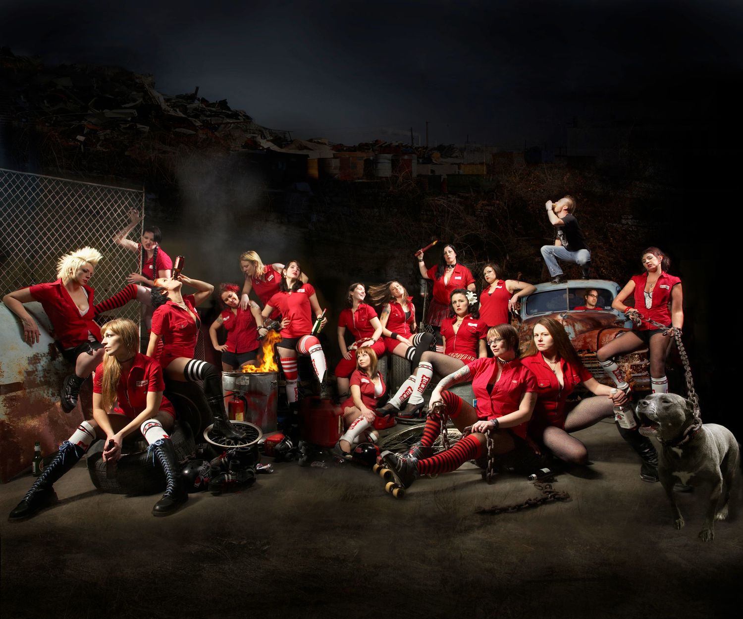 Large group in red uniforms posing together in dramatic nighttime sports photo.