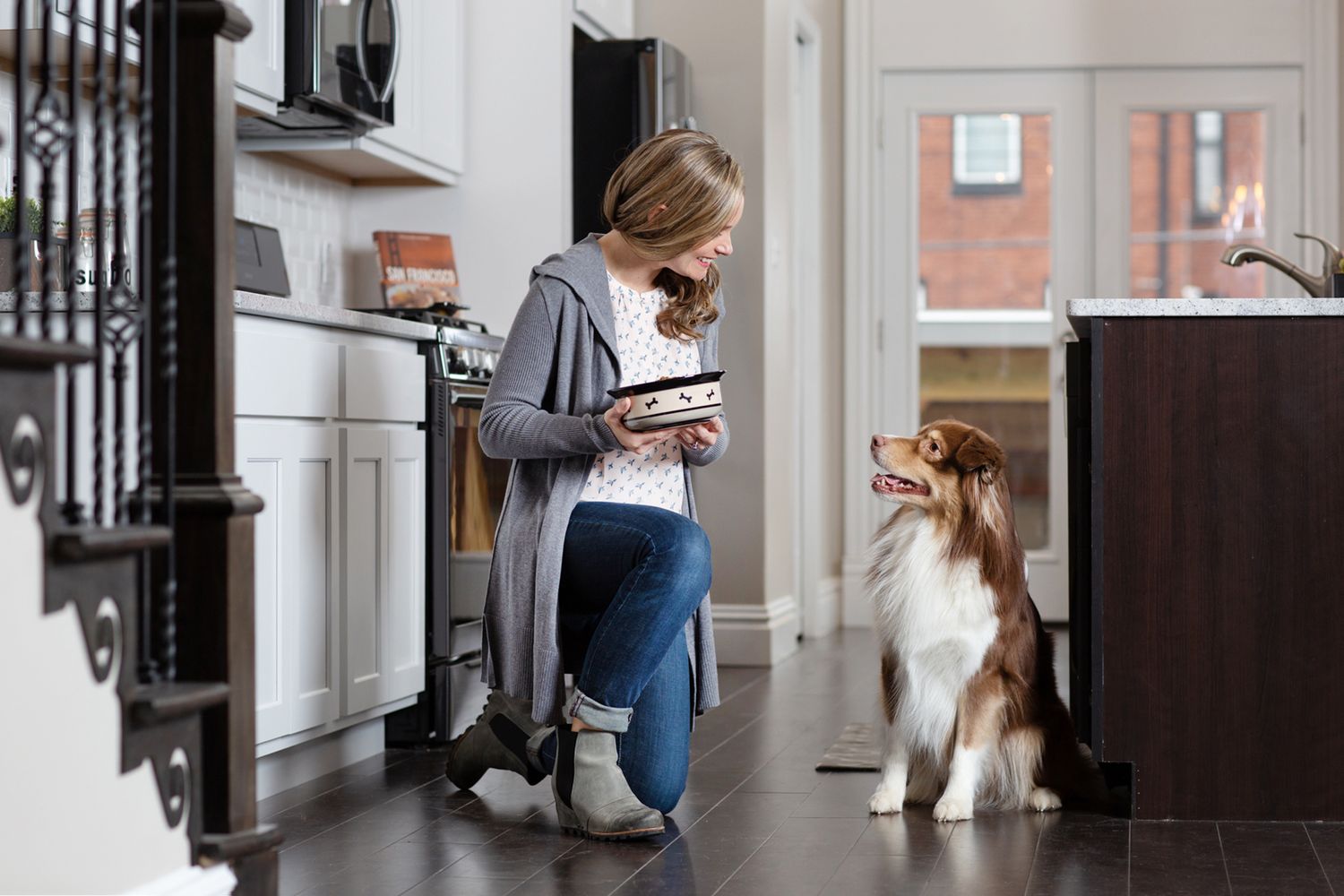 Australian Shepherd standing expectantly in kitchen while meal is being prepared.
