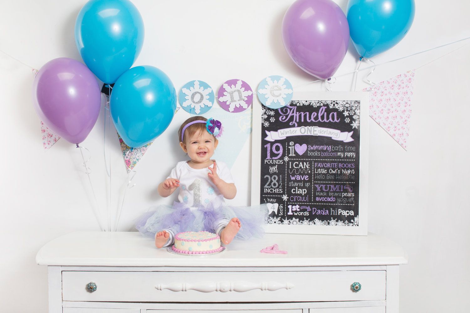 Birthday party setup with blue and purple balloons and decorative chalkboard sign.