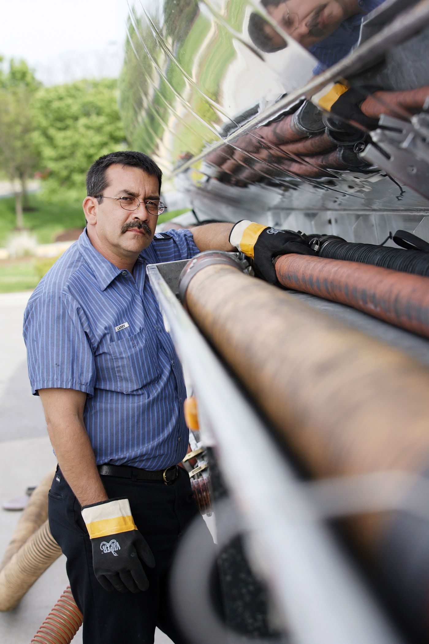 Maintenance technician inspecting industrial equipment outdoors.