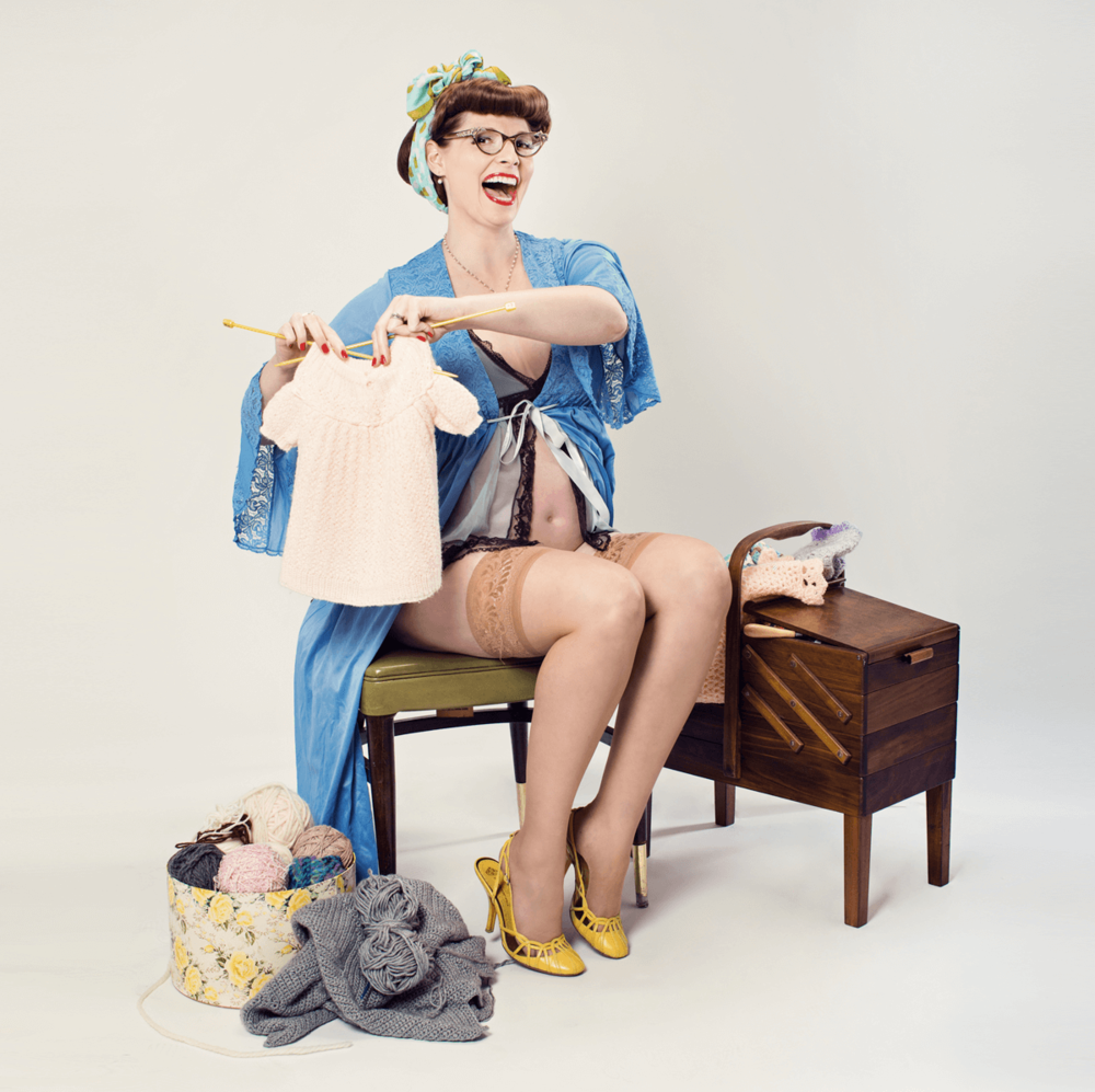 Vintage style portrait of model in blue robe doing laundry with stockings and yellow heels.