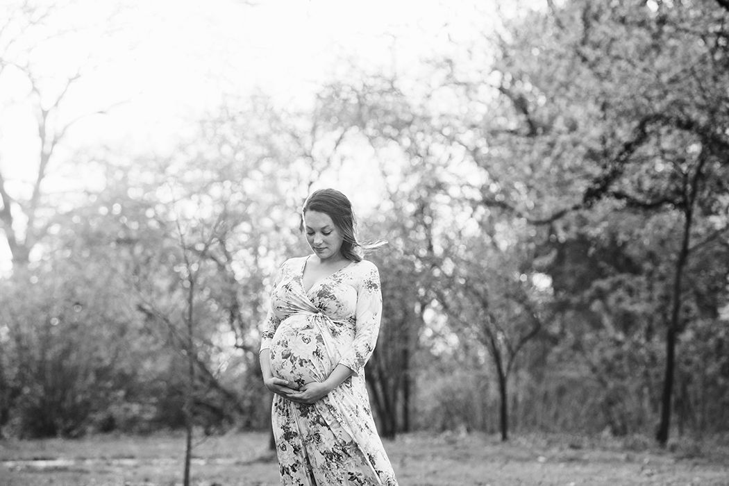Black and white photo of an outdoor wedding ceremony with trees and guests gathered in a natural setting.