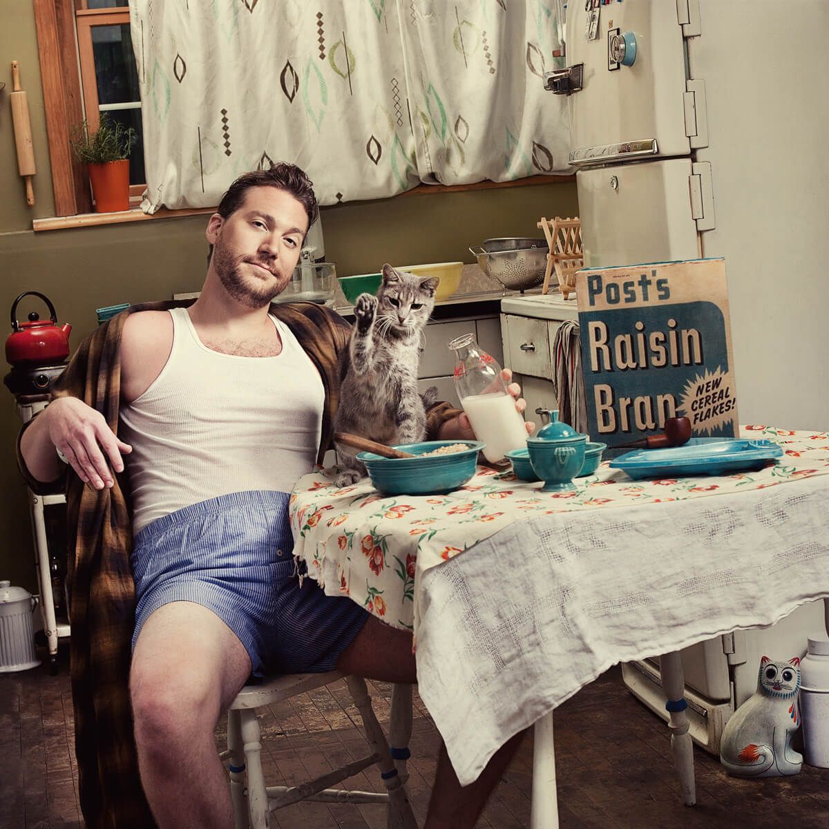 Vintage scene of someone having breakfast with a small dog at a table with Post's Raisin Bran cereal.