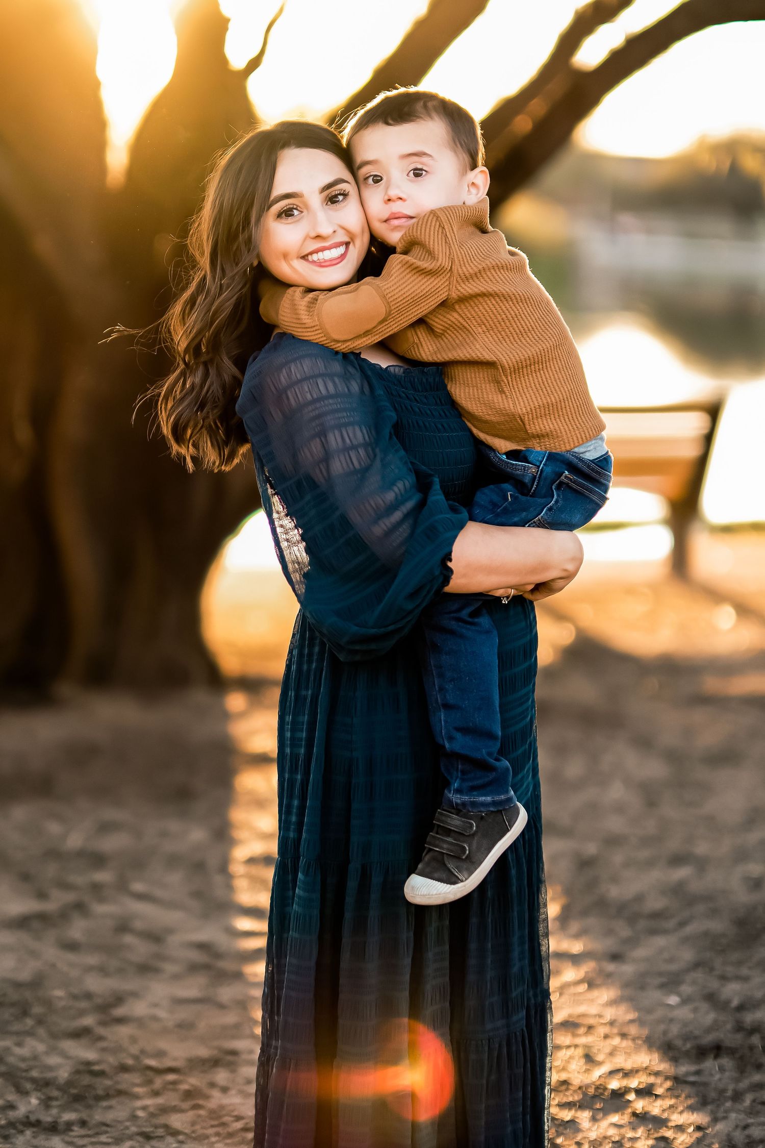 Sunset portrait showing playful moment between parent and child with golden backlighting.