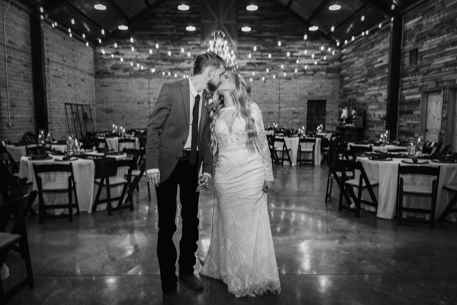 Black and white photo of newlyweds sharing a moment on their reception dance floor.