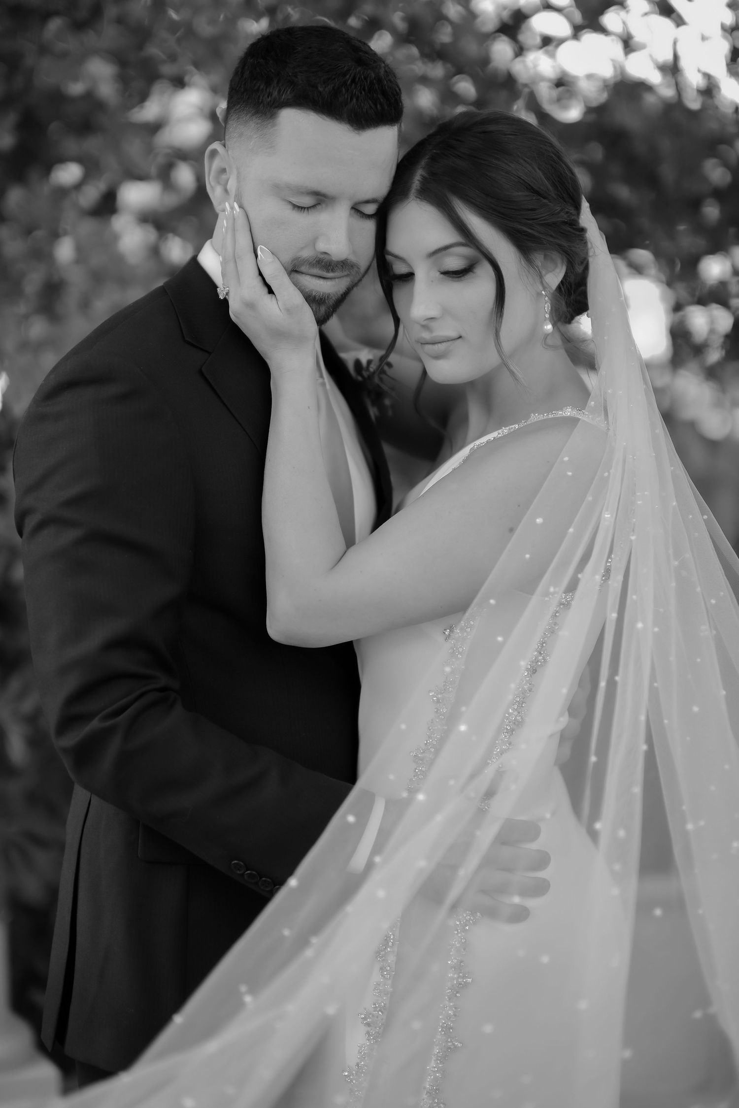 Intimate black and white wedding portrait with sparkly veil detail.