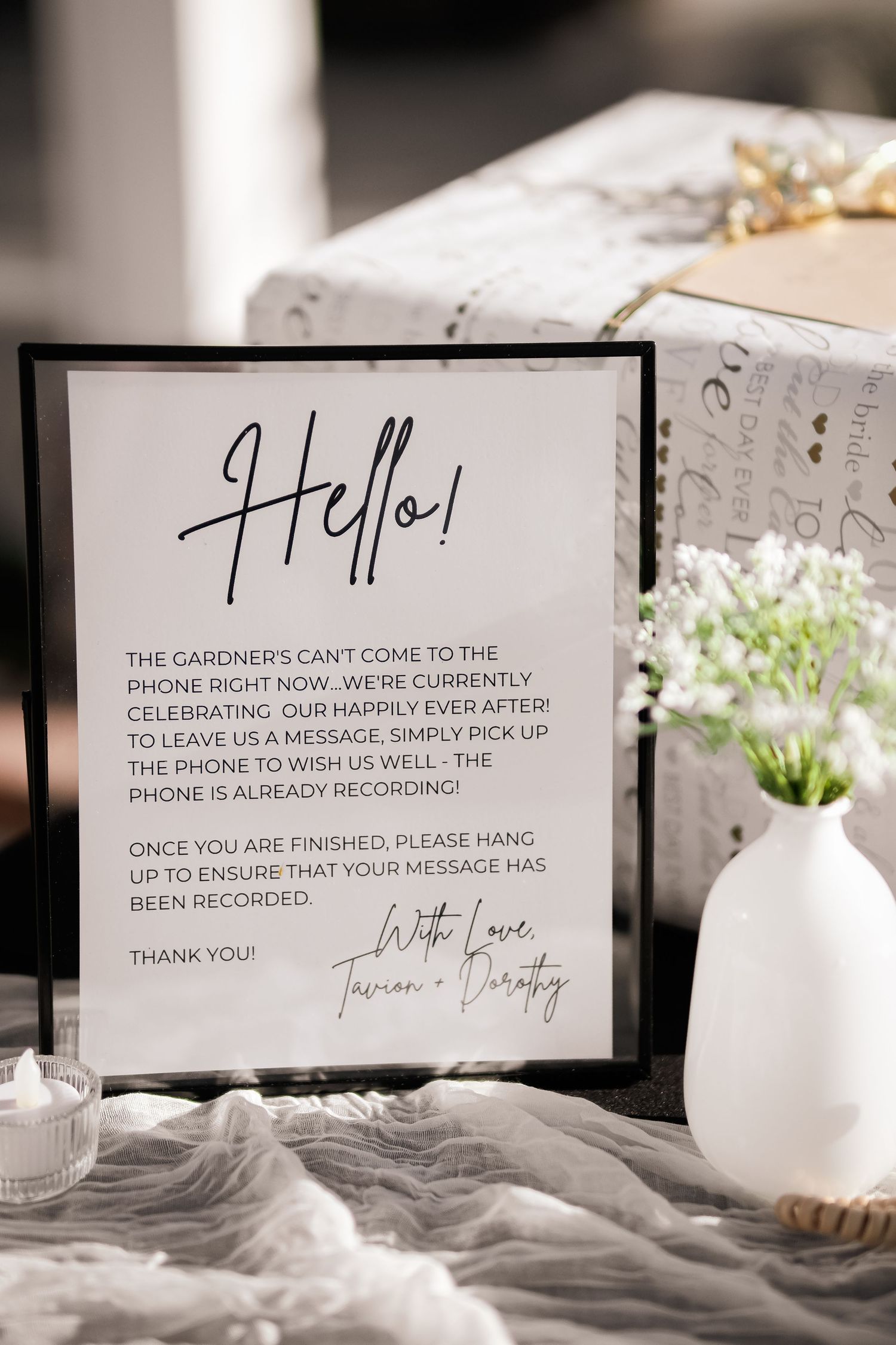Wedding reception sign with elegant font explaining phone policy on display with flowers.