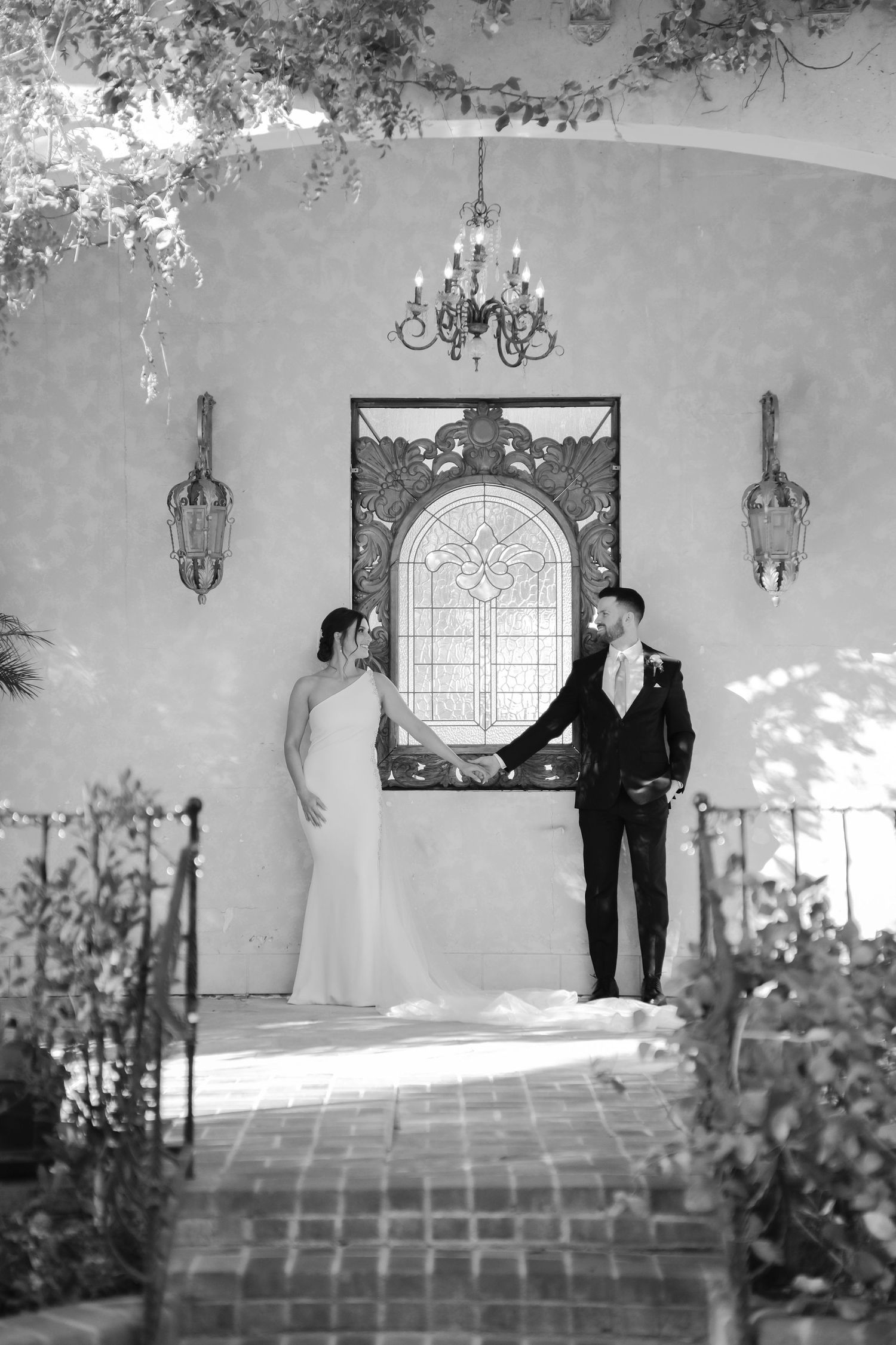 A black and white wedding photo sequence showing a couple in formal attire posing against a light colored wall.