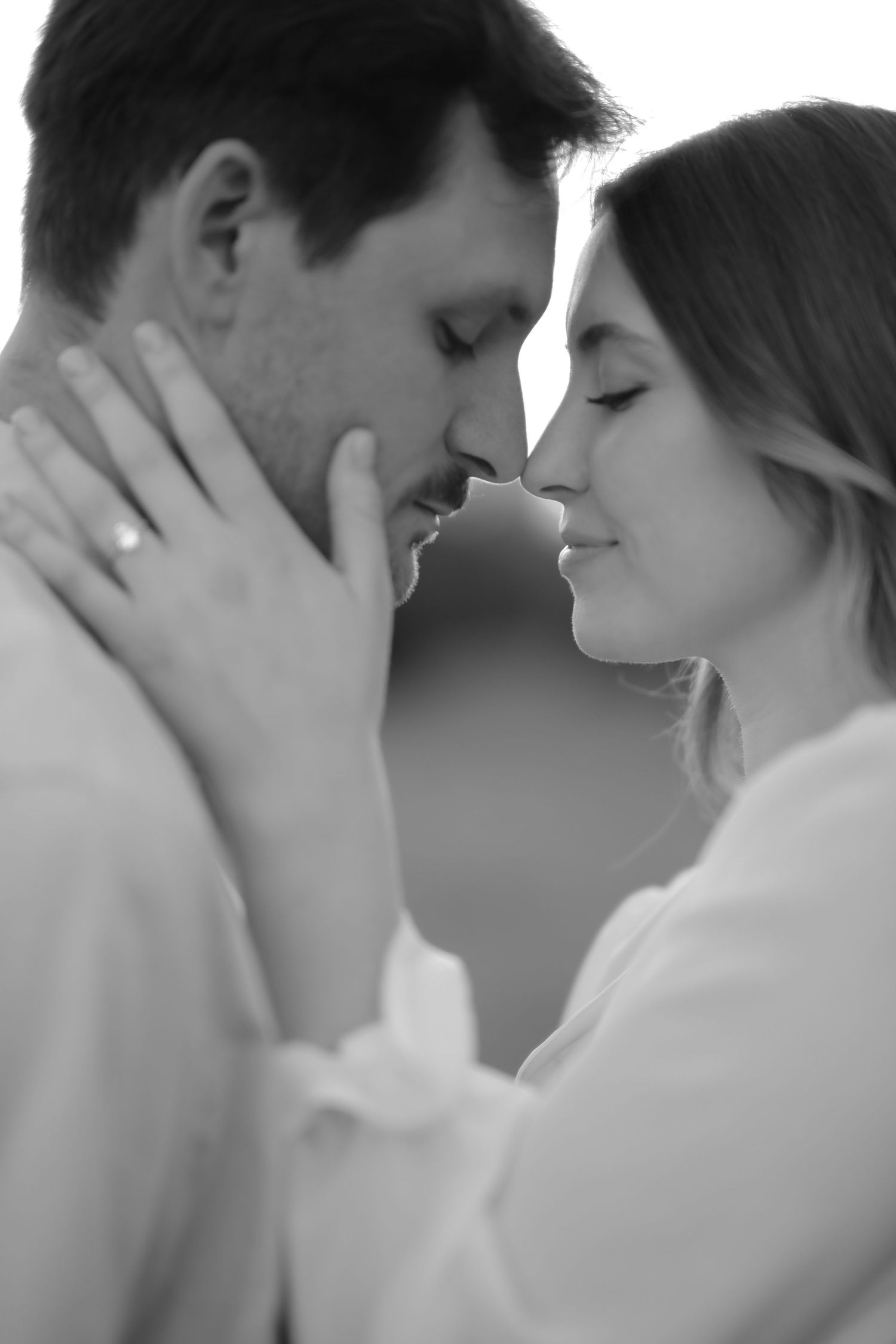 Intimate black and white portrait of couple sharing tender moment.