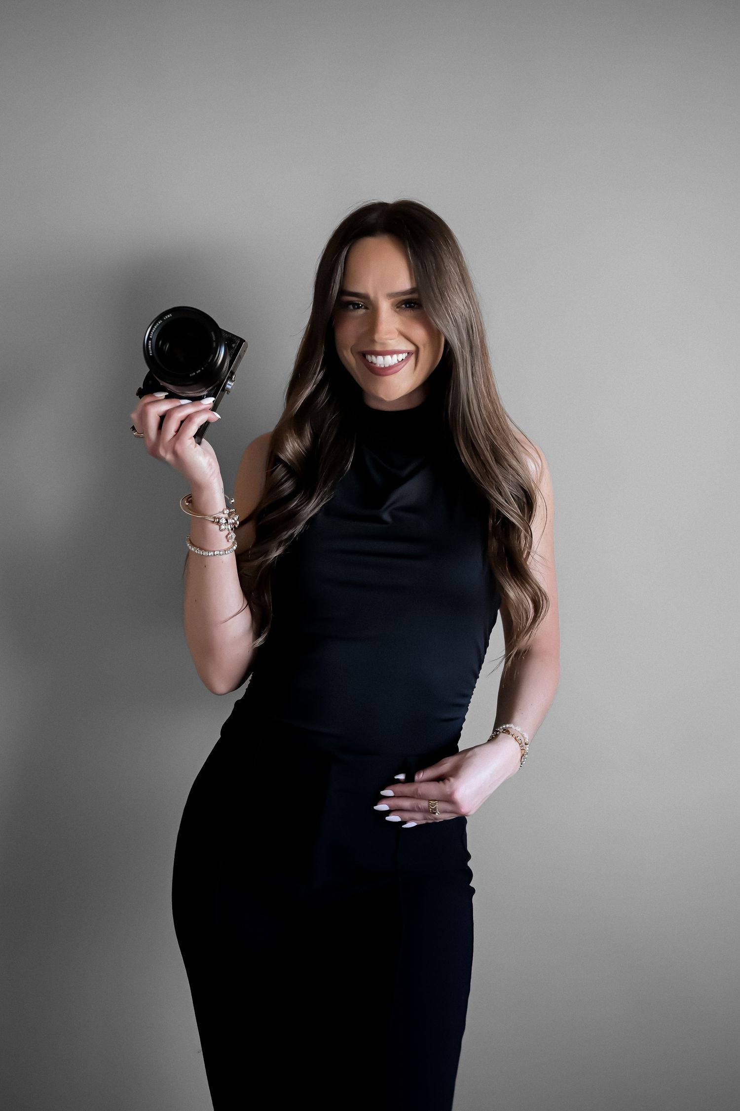 A series of black and white fashion portraits showing a person in a black dress posing against a gray background.