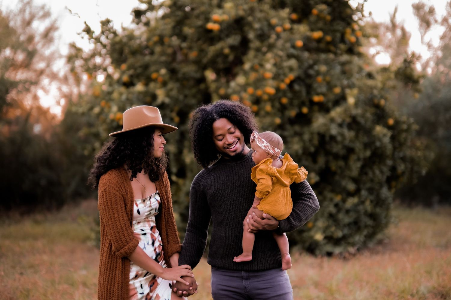 Three people sharing a joyful moment together in an autumn garden setting.