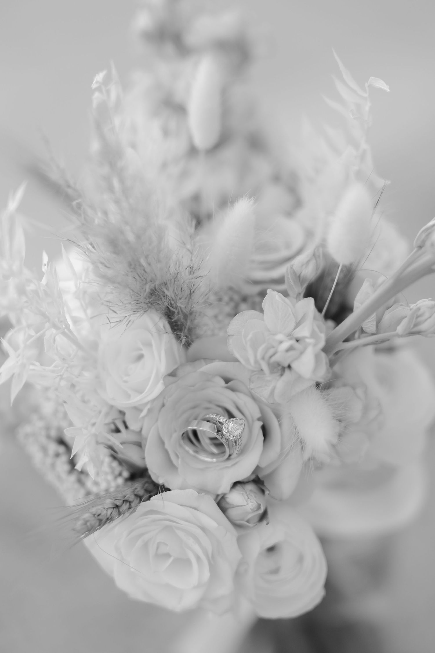 Monochrome close-up of an elegant floral arrangement with roses and textural elements.