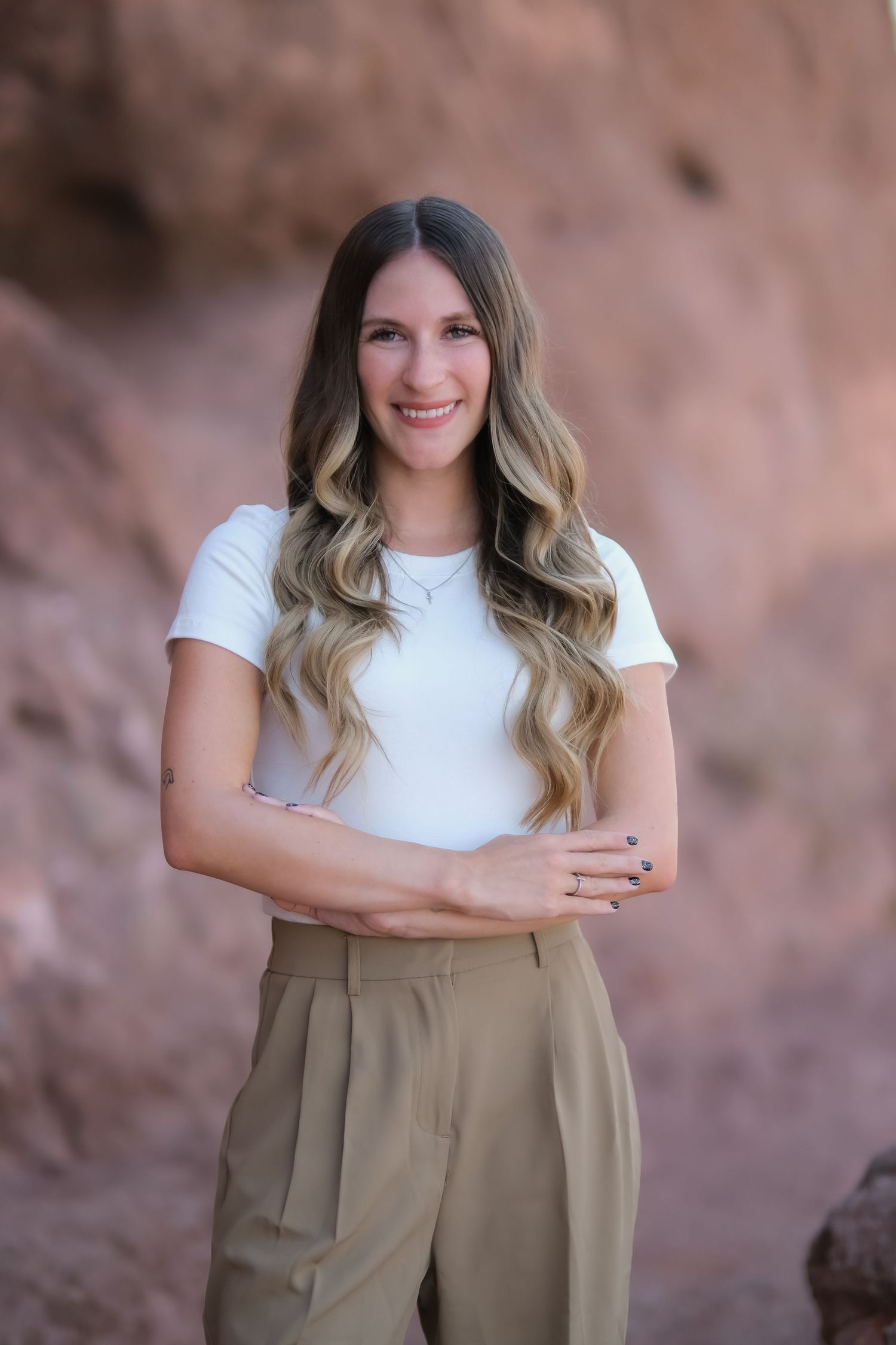 Professional portrait outdoors with red rock formations in background.